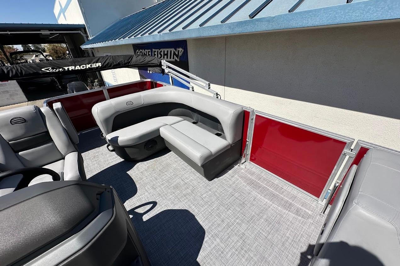 2026 Sun Tracker Party Barge 18 DLX interior with gray seating and red paneling.