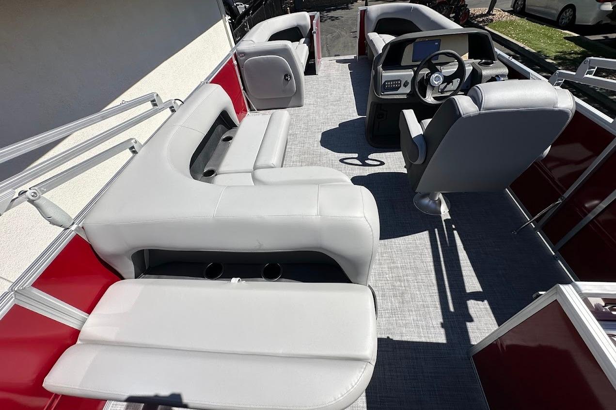 2026 Sun Tracker Party Barge 18 DLX interior with gray seating and steering console.