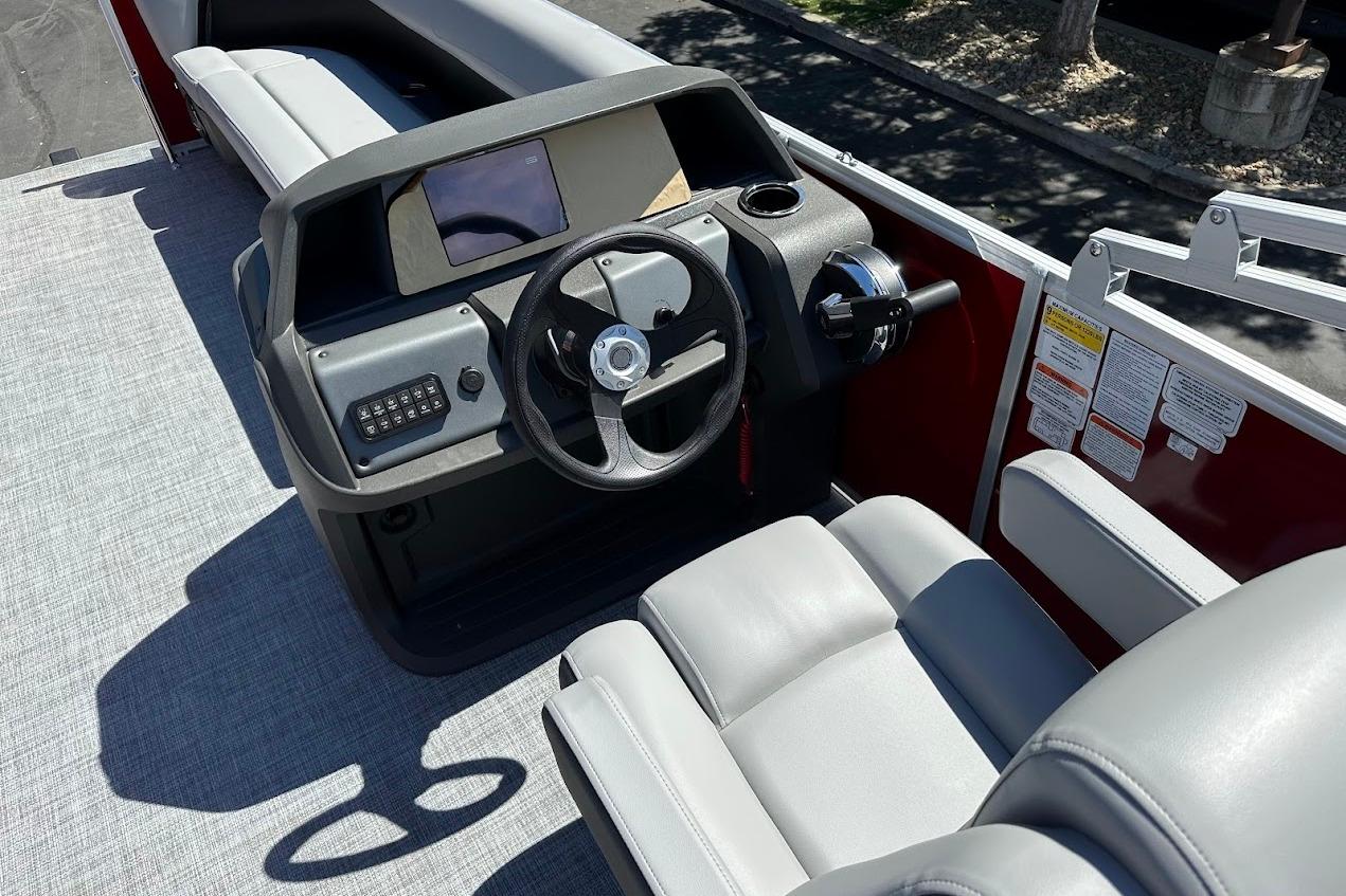 2026 Sun Tracker Party Barge 18 DLX boat interior with steering console and seating.