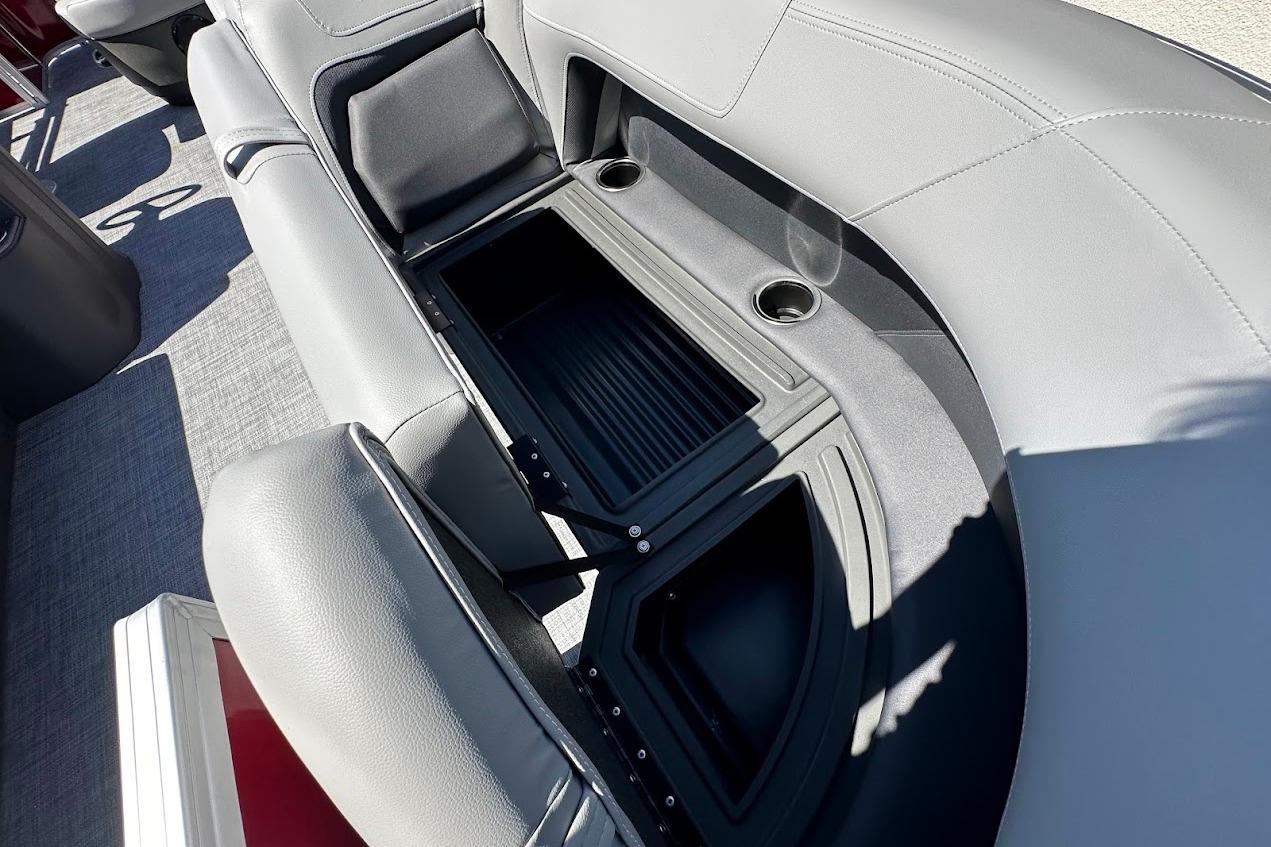 2026 Sun Tracker Party Barge 18 DLX interior with open storage compartment and cup holders.