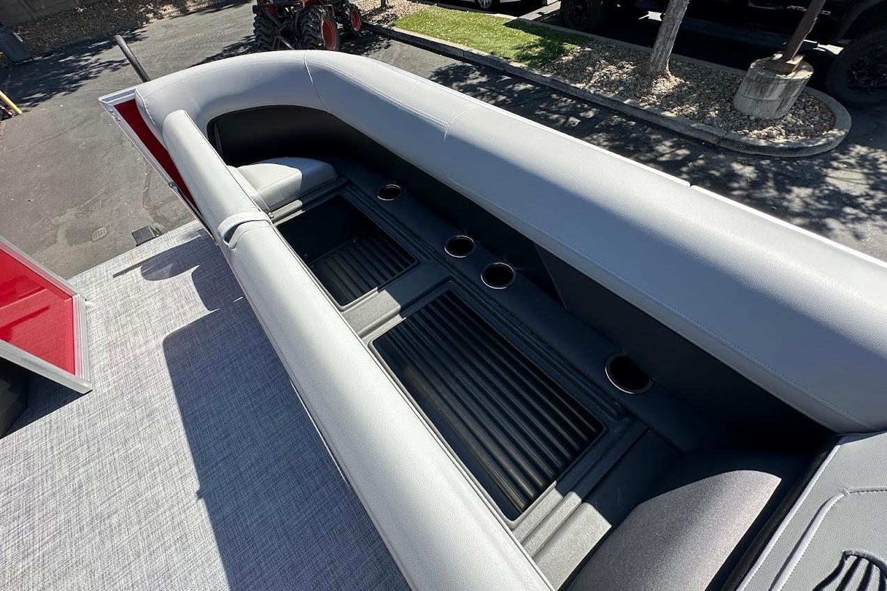 2026 Sun Tracker Party Barge 18 DLX interior with gray seating and cup holders.