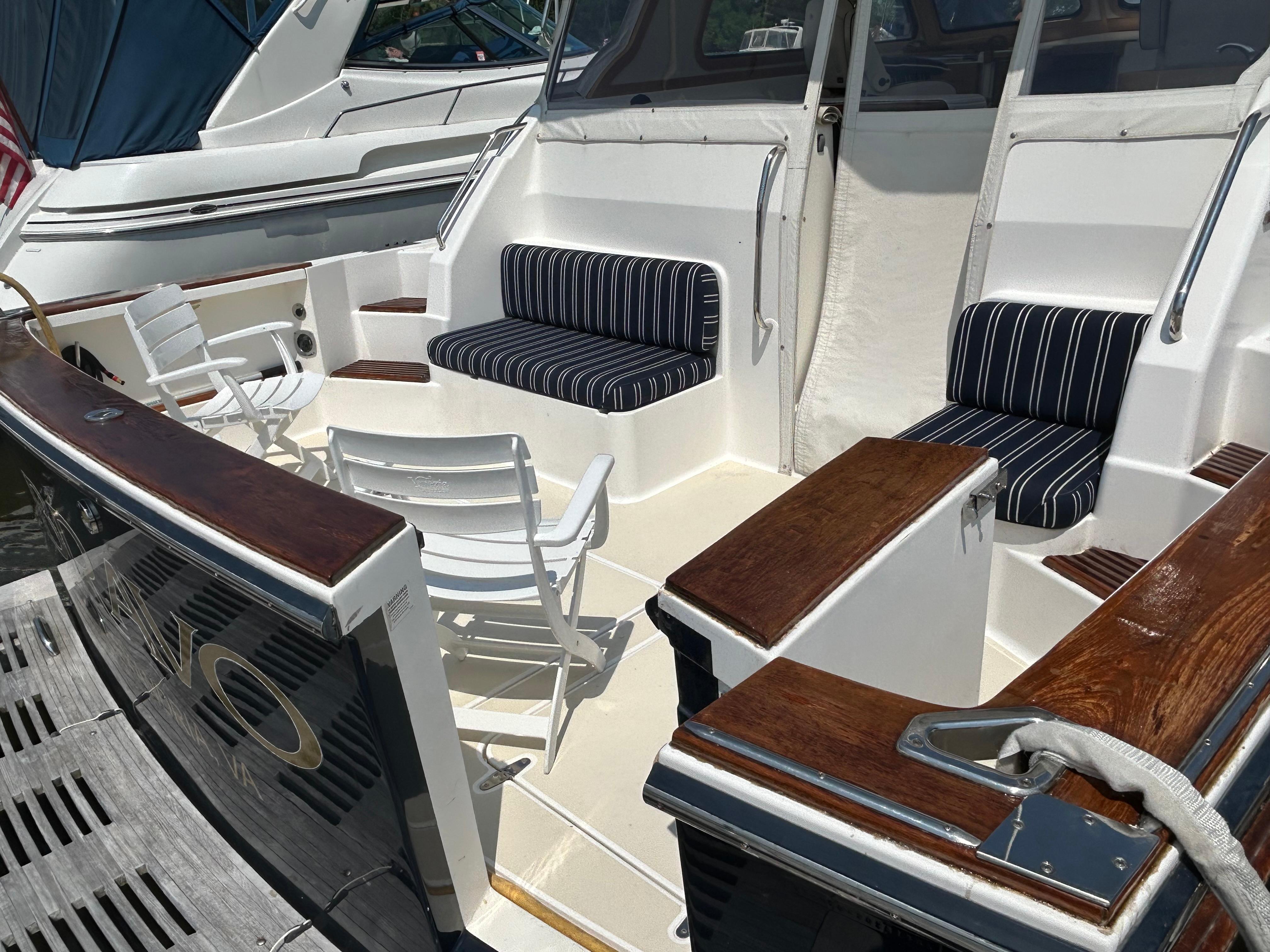 2005 Sabre 42 Hardtop Express yacht with striped seating and white chairs on deck.
