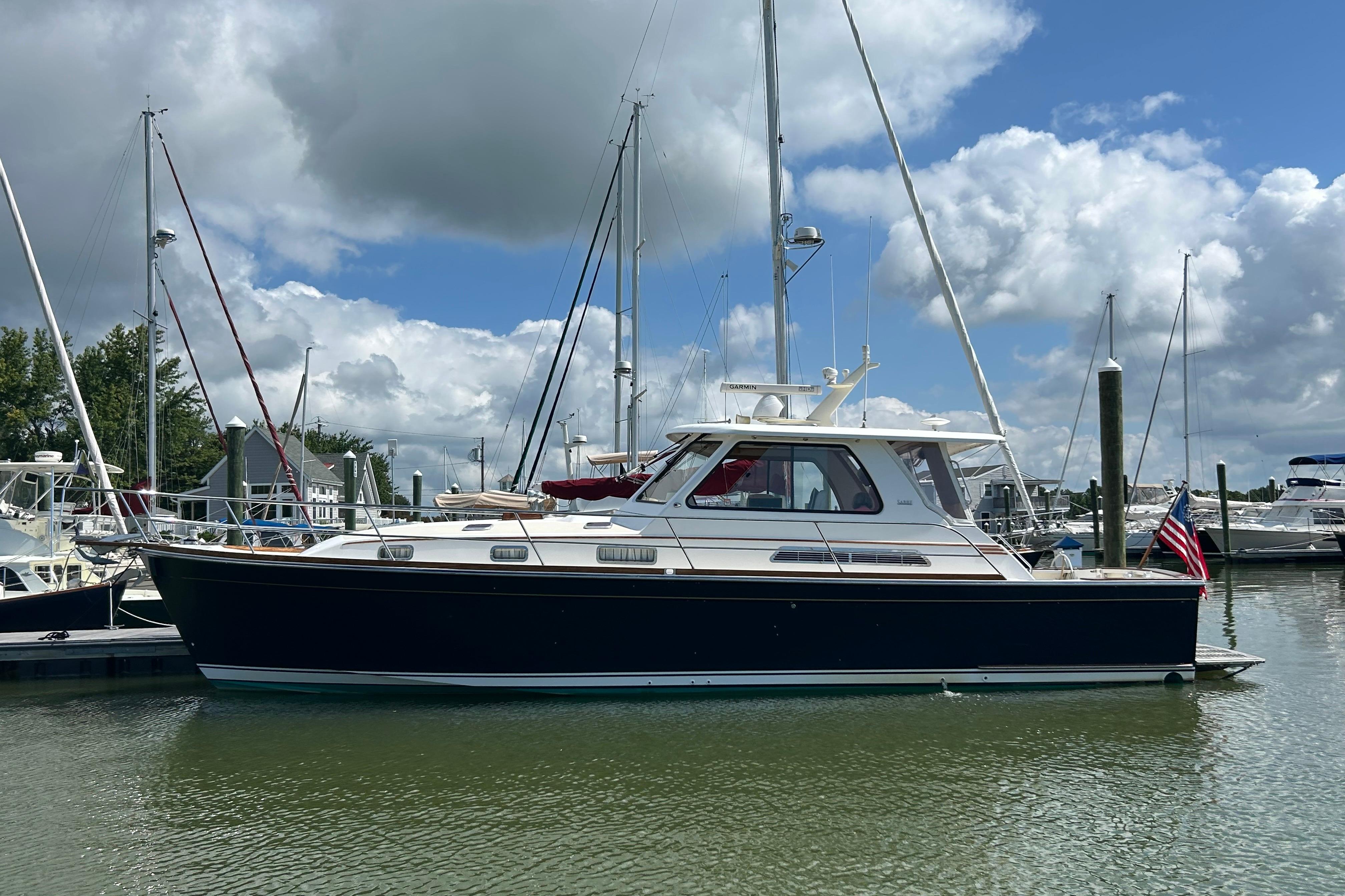 2005 Sabre 42 Hardtop Express yacht docked in a marina under a cloudy sky.