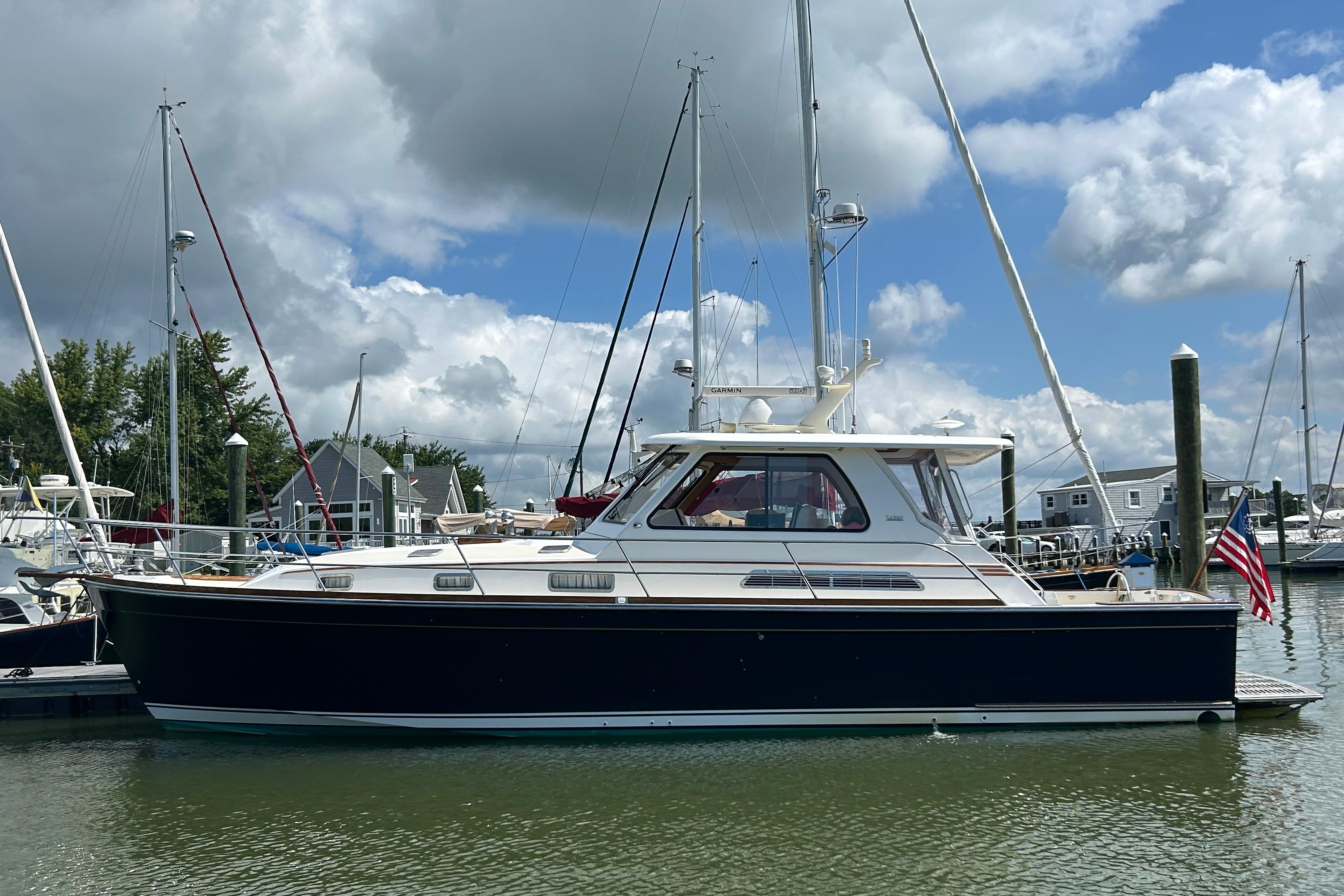 2005 Sabre 42 Hardtop Express yacht docked in a marina under cloudy skies.