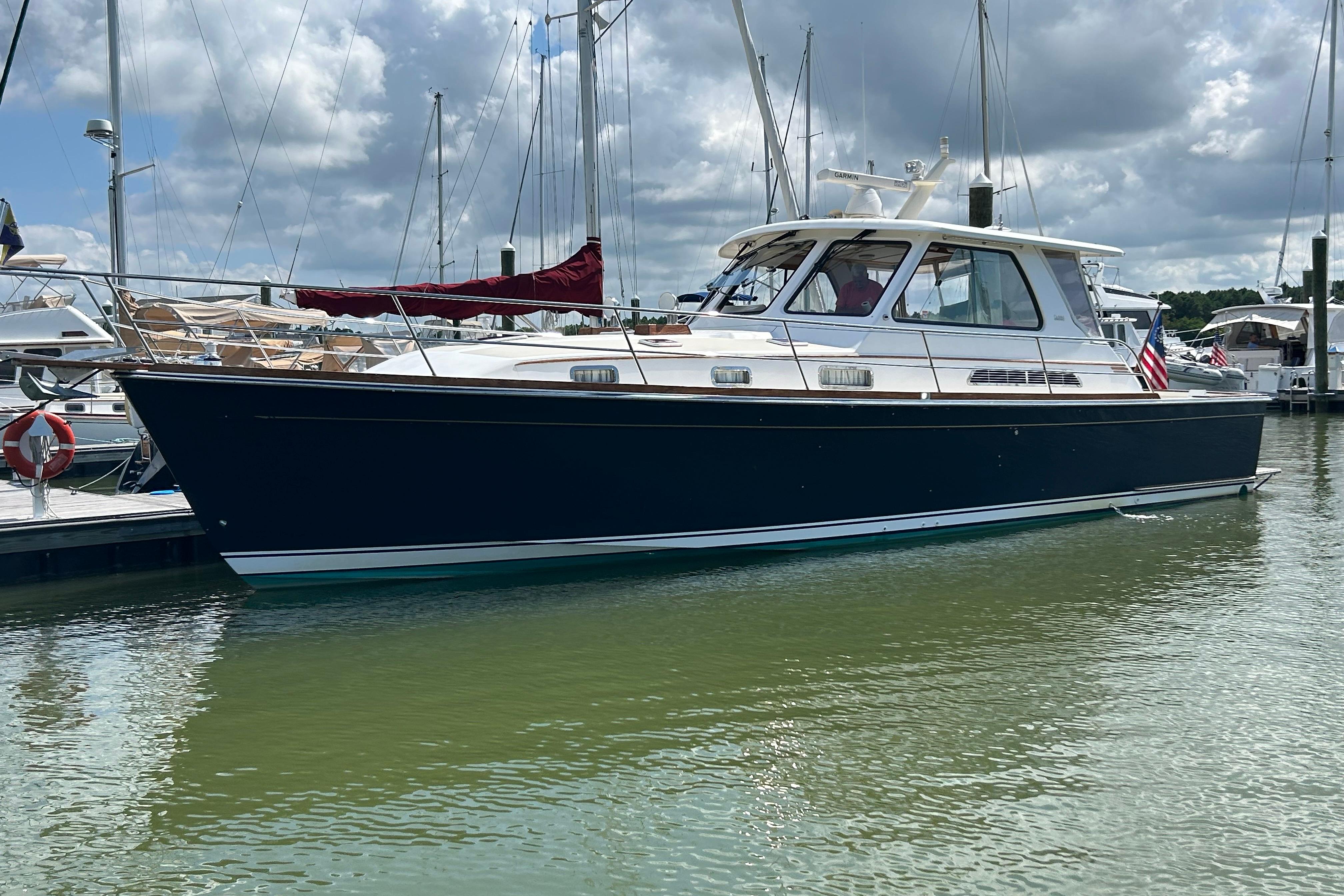 2005 Sabre 42 Hardtop Express yacht docked in a marina under cloudy skies.