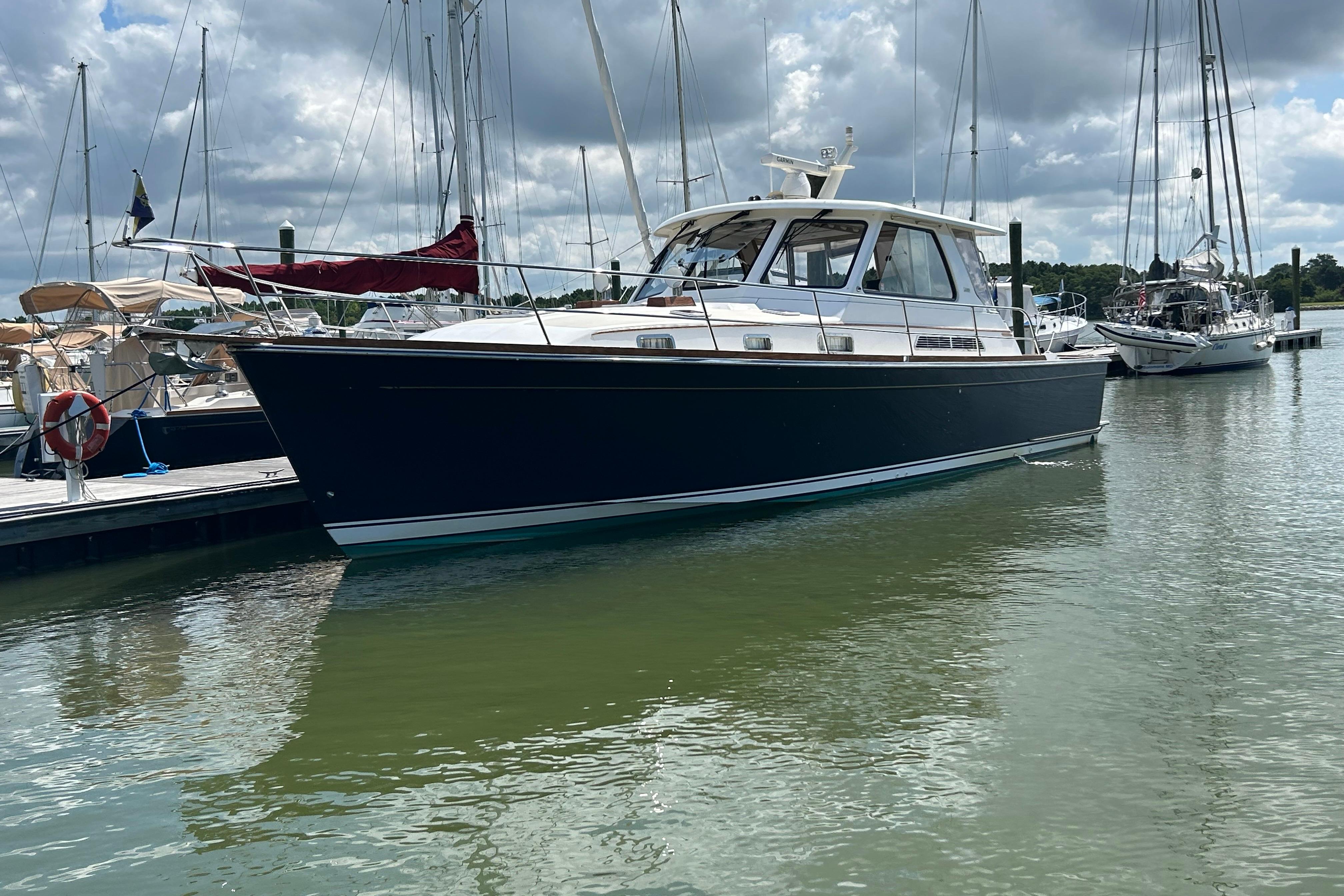 2005 Sabre 42 Hardtop Express yacht docked in a marina under cloudy skies.