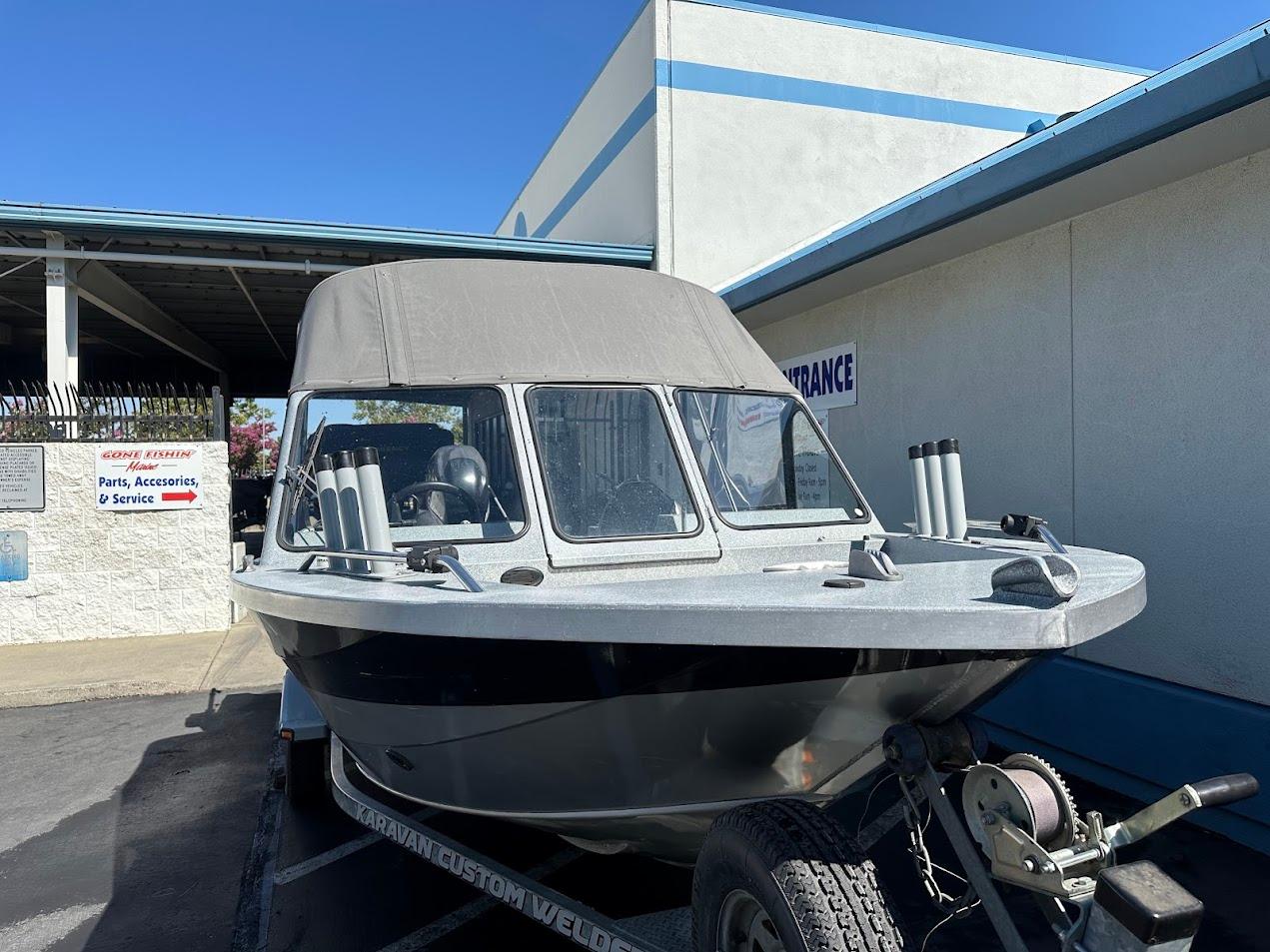 Jetcraft 1925 Adventurer boat, 2008 model, parked outside a service center under clear blue sky.