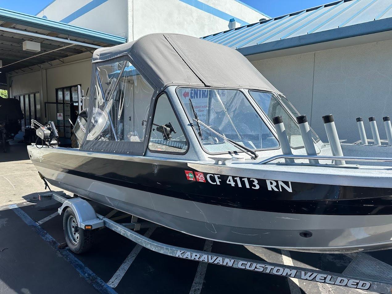 Jetcraft 1925 Adventurer 2008 boat on trailer, parked outside building.