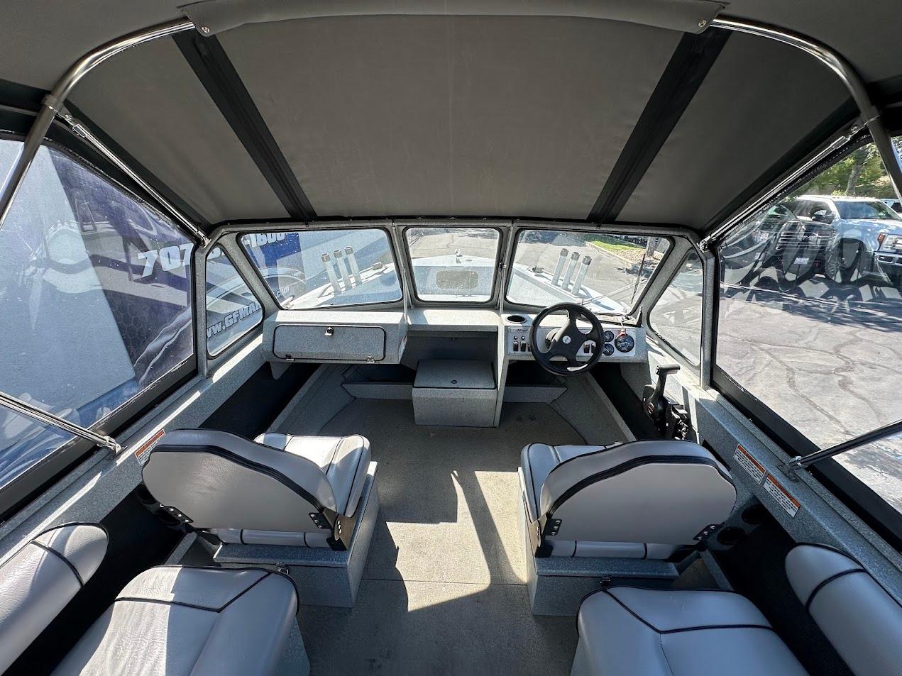 Interior of a 2008 Jetcraft 1925 Adventurer boat, featuring seating and steering console.