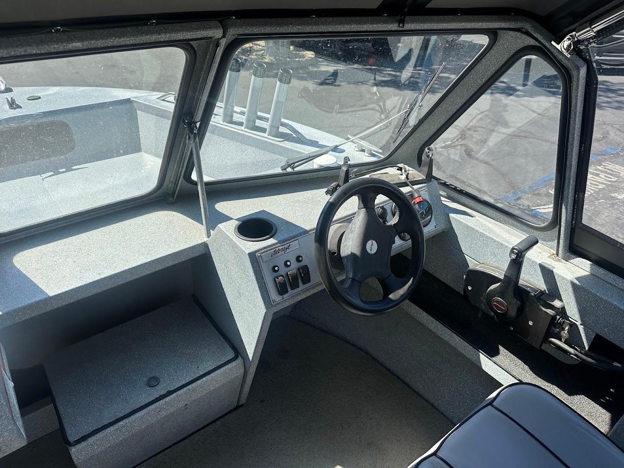 Interior of a 2008 Jetcraft 1925 Adventurer boat, featuring steering wheel and control panel.