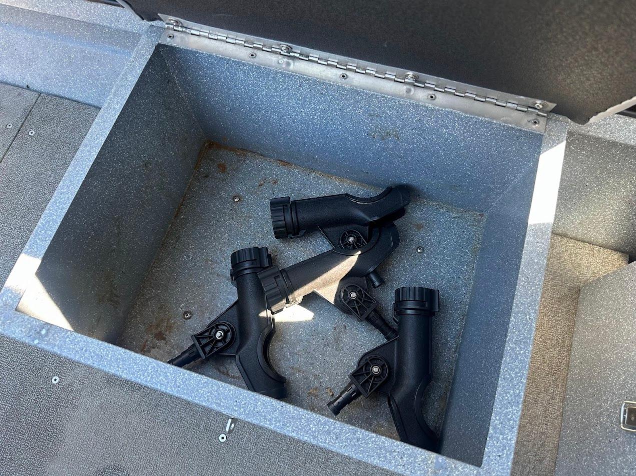 Open storage compartment with black rod holders in a 2008 Jetcraft 1925 Adventurer boat.