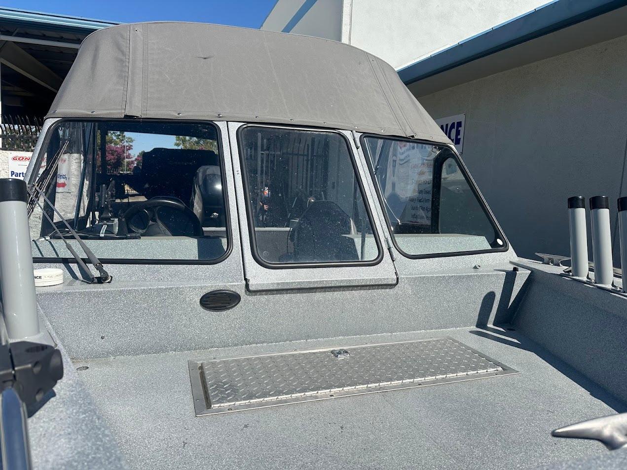 Jetcraft 1925 Adventurer boat, 2008 model, with canopy and windshield, parked outdoors.