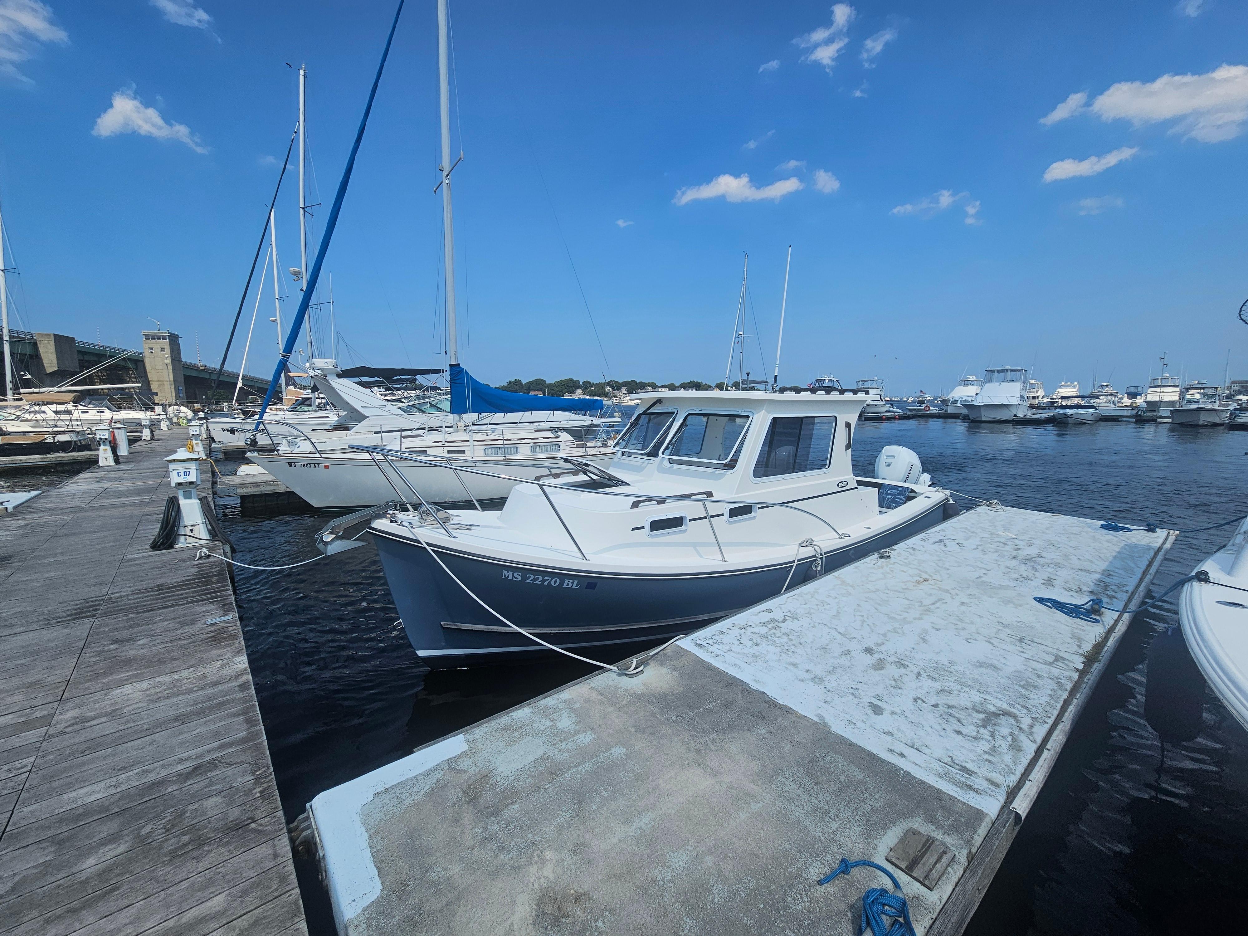 2019 Eastern 248 Explorer boat docked at a marina under a clear blue sky.