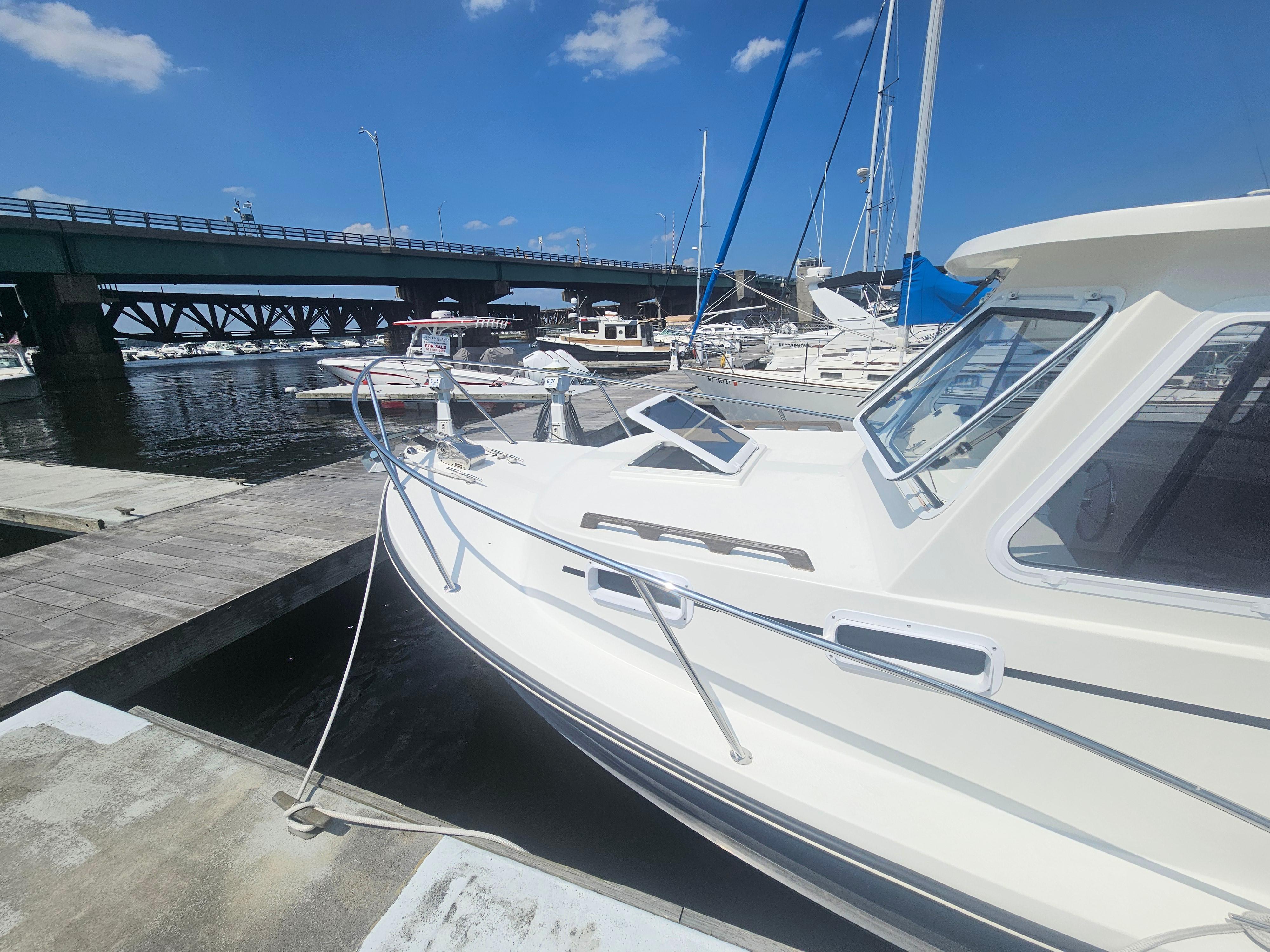 2019 Eastern 248 Explorer boat docked near a bridge under a clear blue sky.