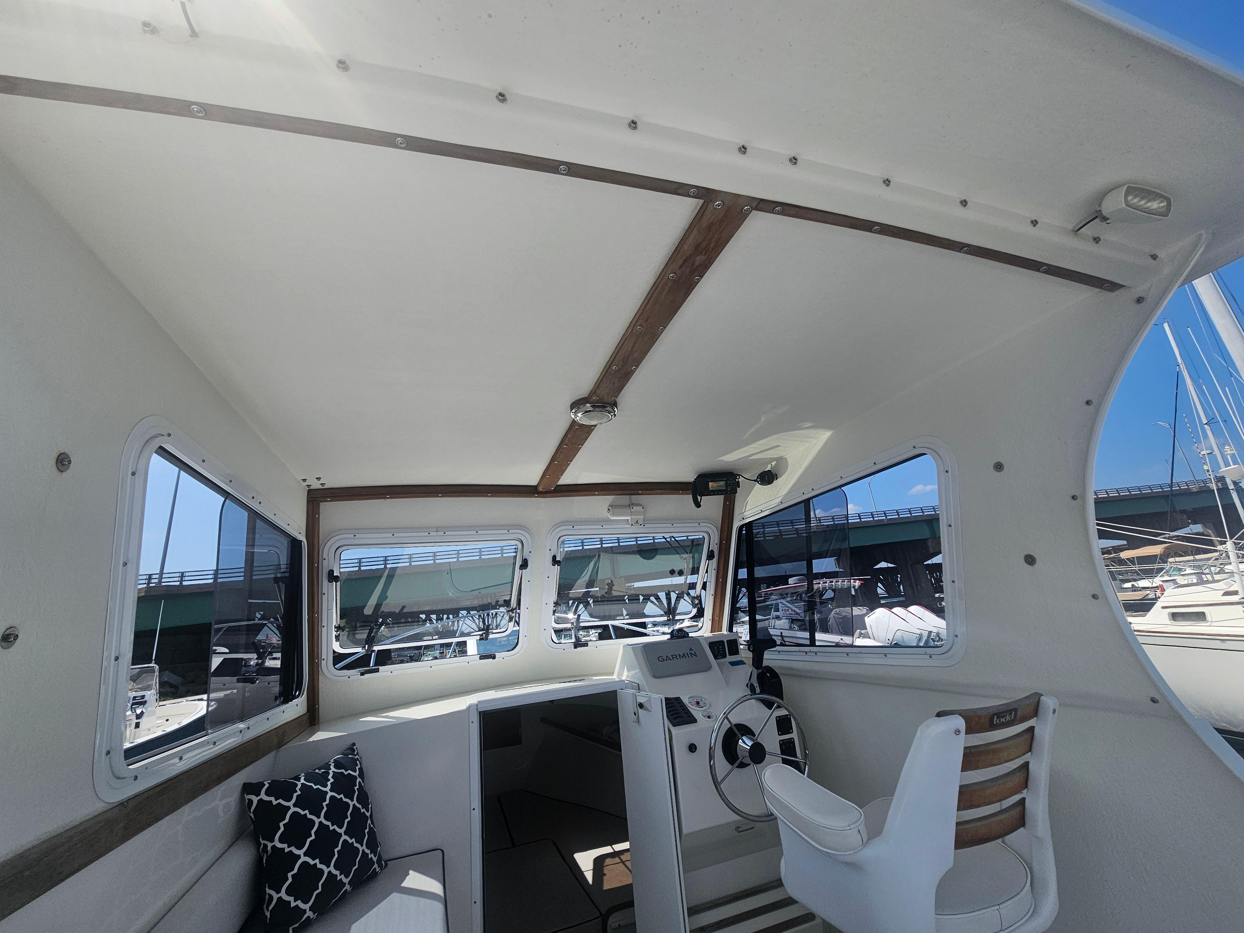 Interior of 2019 Eastern 248 Explorer boat with helm, windows, and seating.