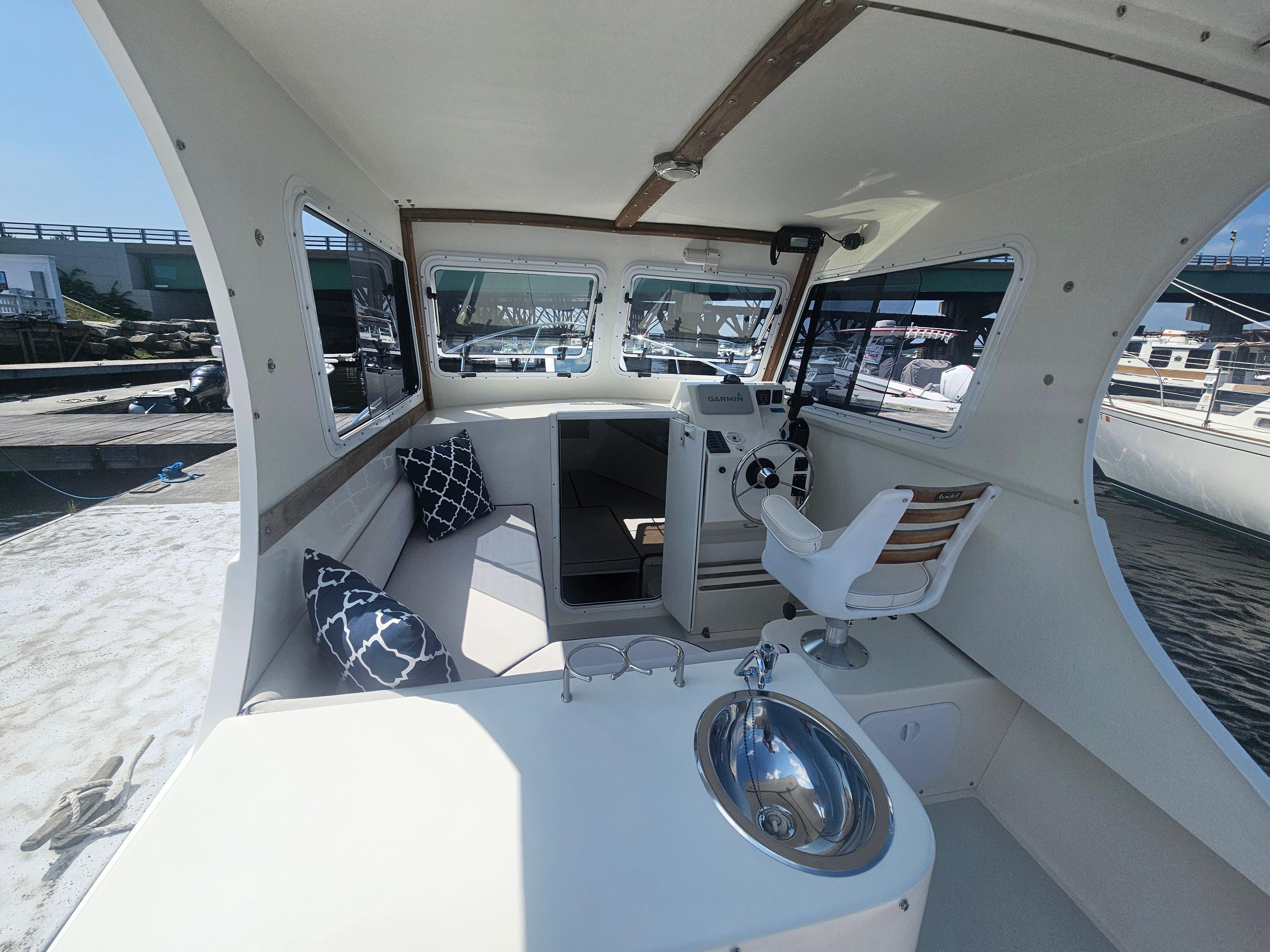 2019 Eastern 248 Explorer boat interior with helm, seating, and sink, docked at marina.