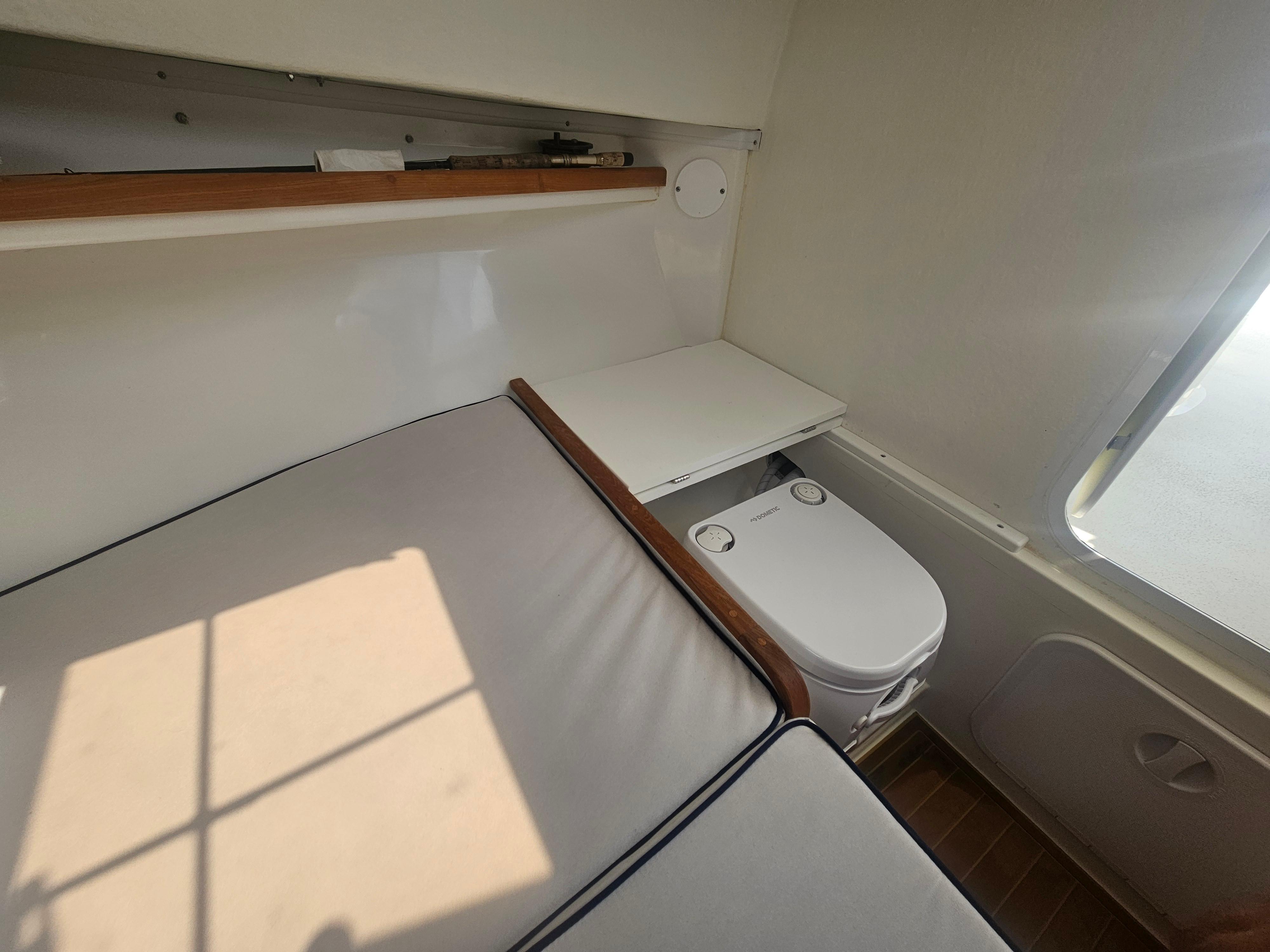 2019 Eastern 248 Explorer cabin interior with compact toilet and cushioned seating.