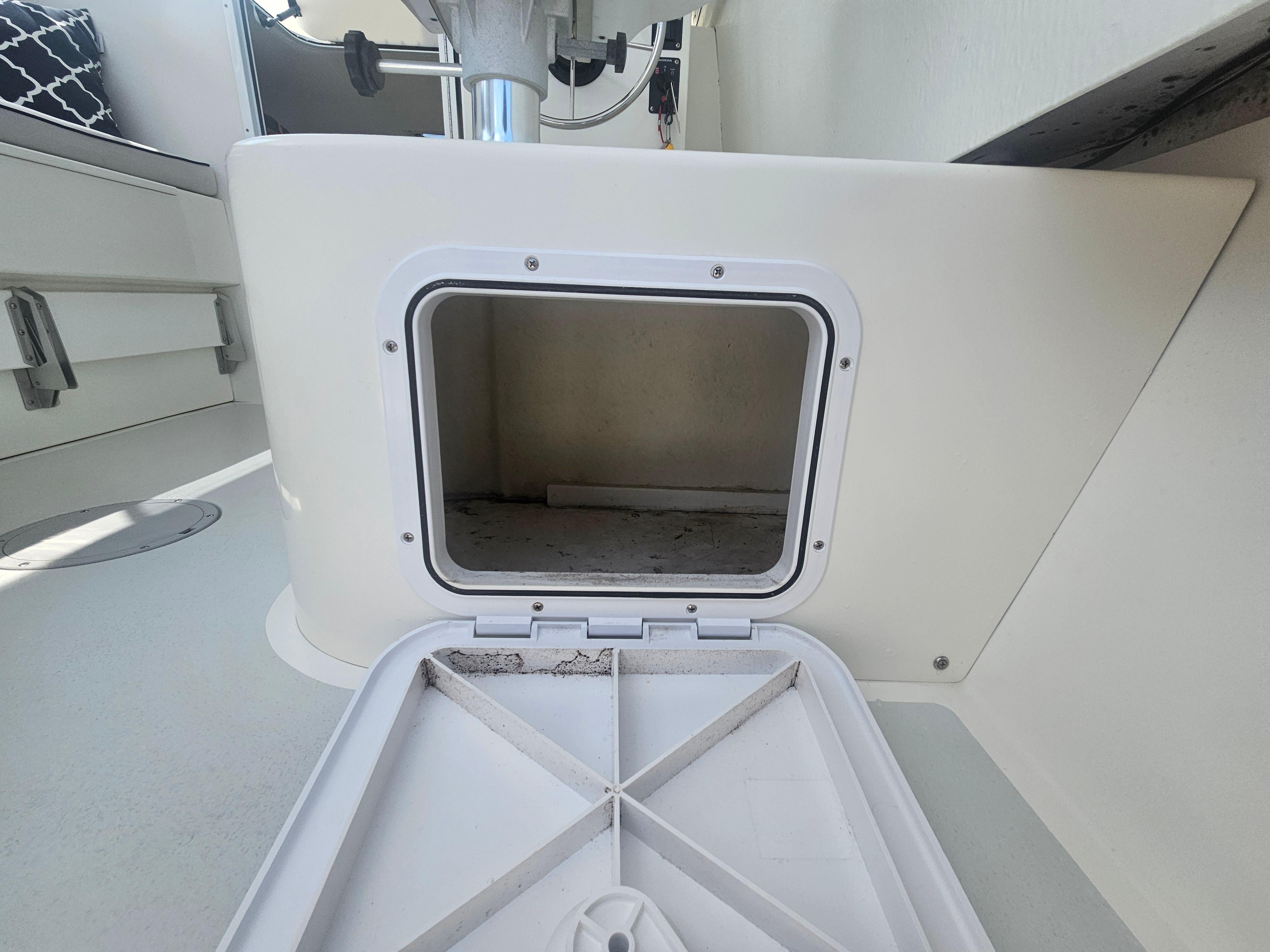 Open storage compartment on 2019 Eastern 248 Explorer boat interior.