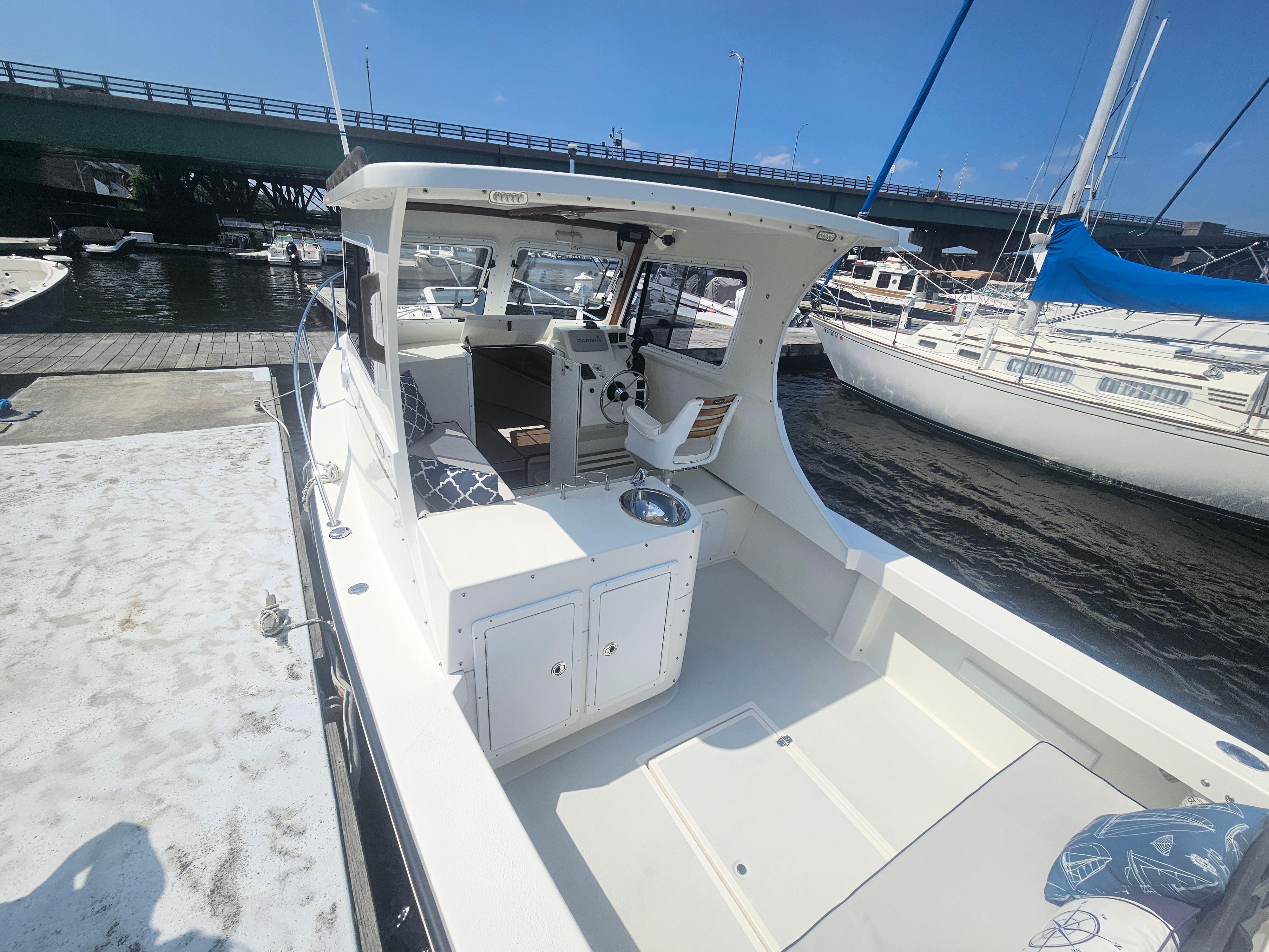 2019 Eastern 248 Explorer boat docked near a bridge on a sunny day.
