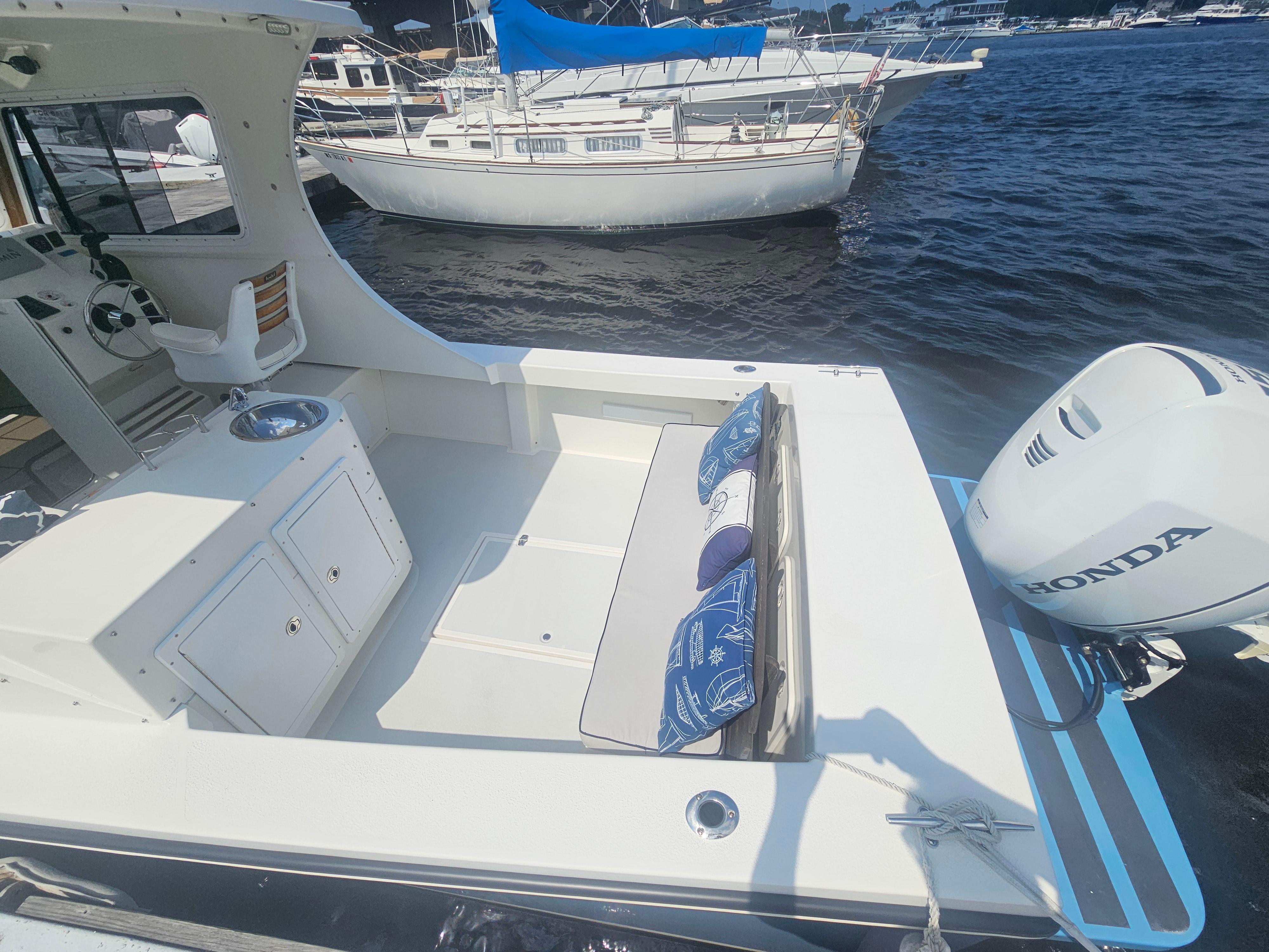 2019 Eastern 248 Explorer boat with Honda outboard motor, docked near other boats.