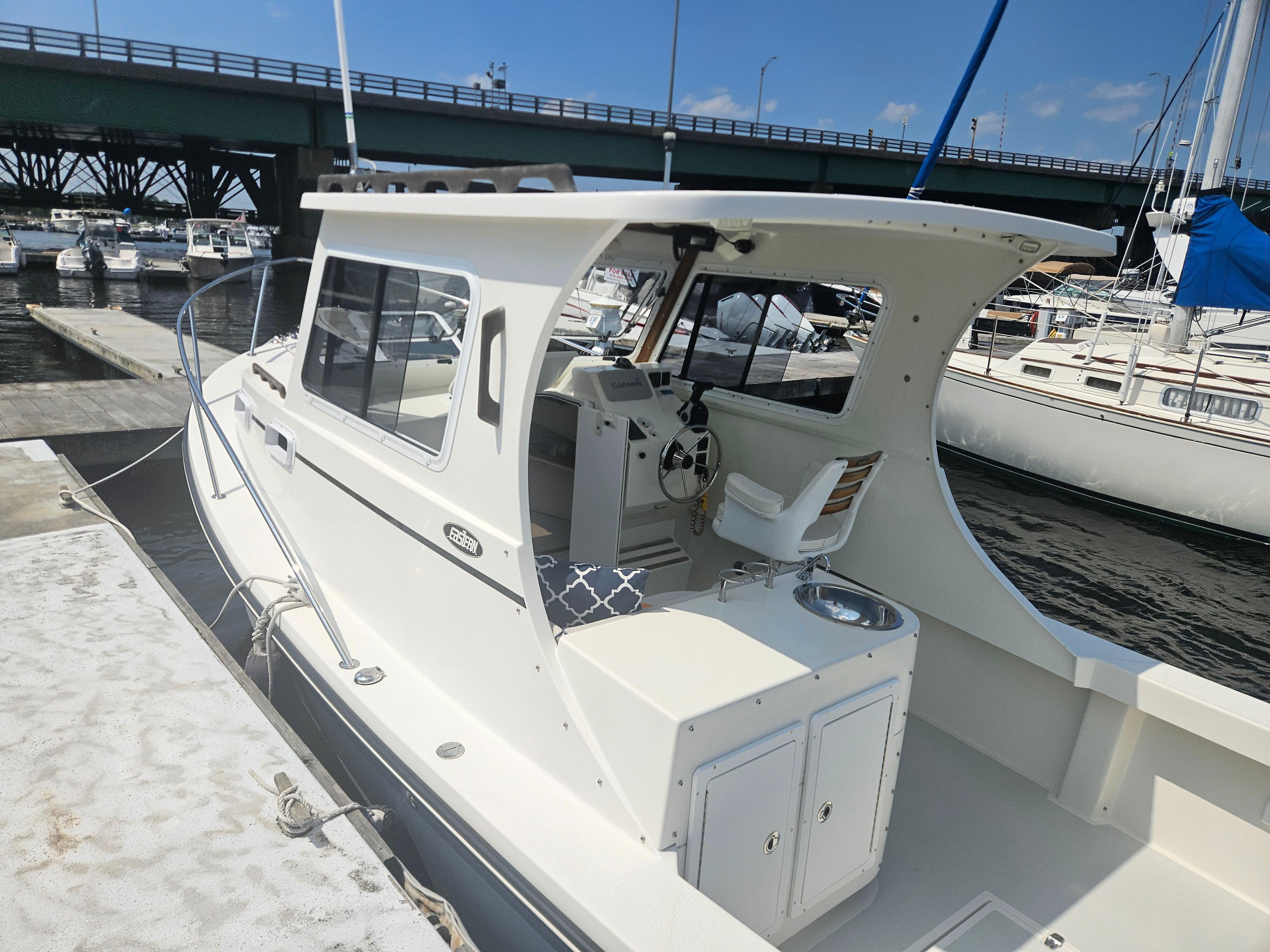2019 Eastern 248 Explorer boat docked at marina, featuring a spacious cockpit and helm.