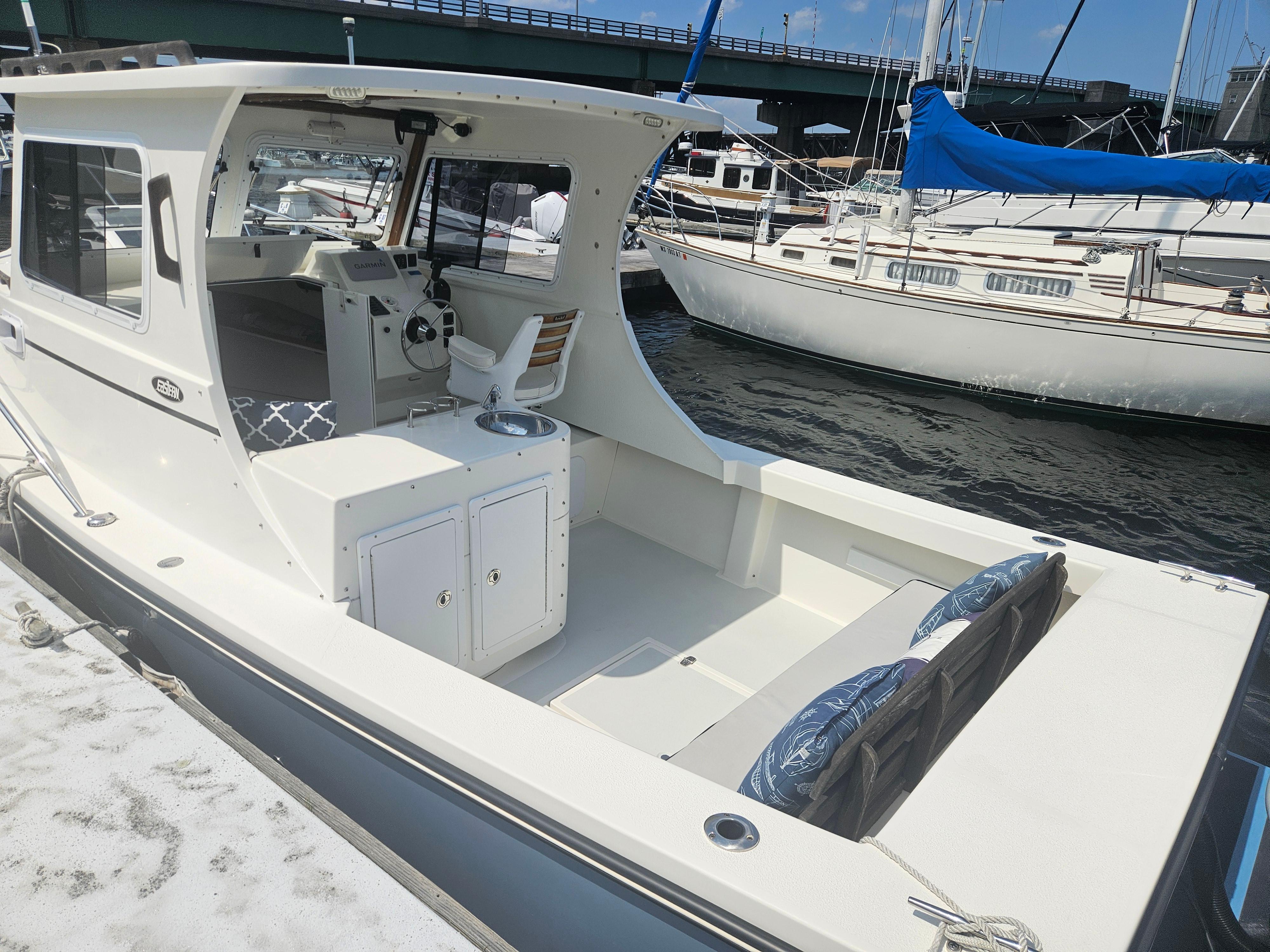2019 Eastern 248 Explorer boat docked at marina, featuring spacious cockpit and helm.