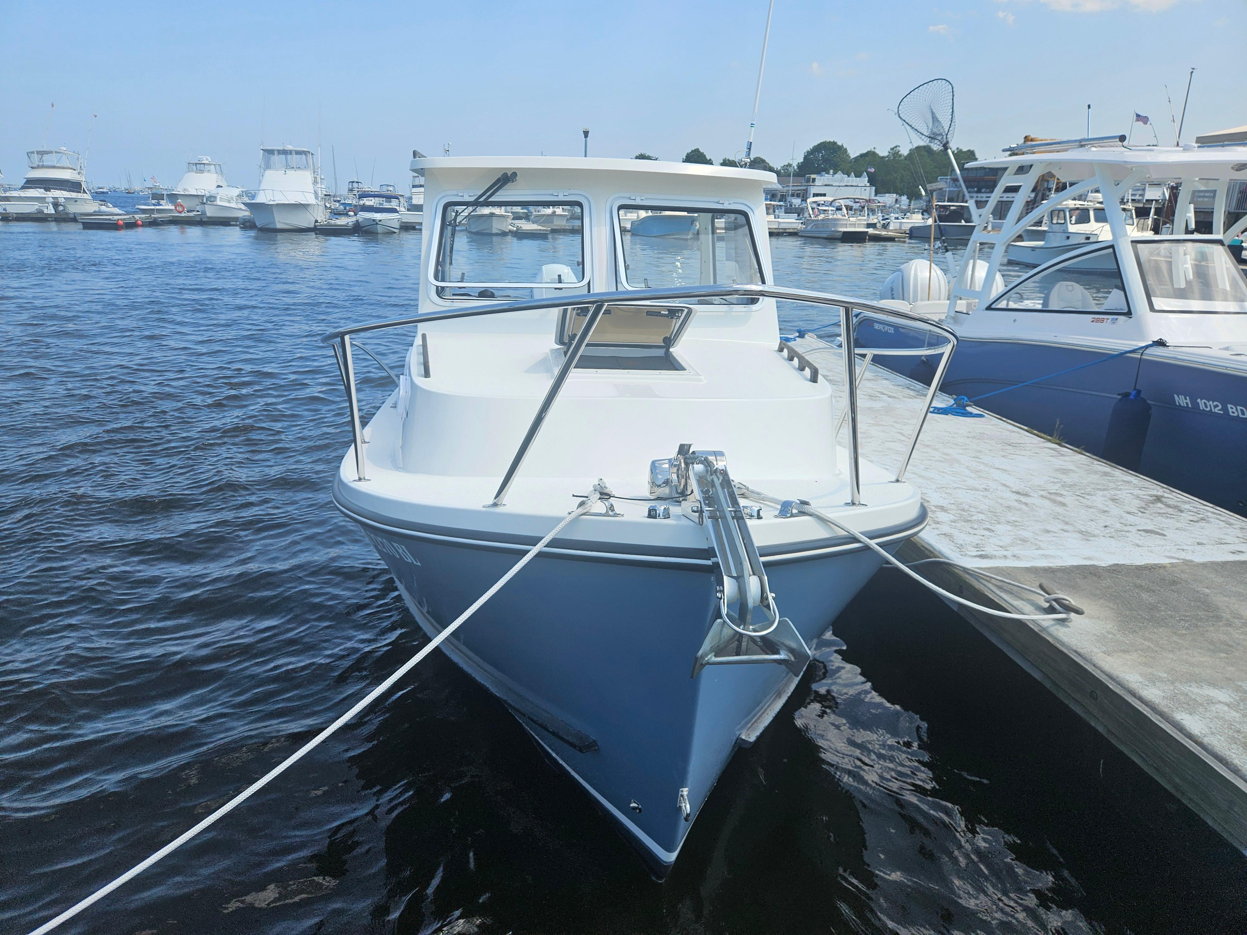 2019 Eastern 248 Explorer boat docked at marina, surrounded by other vessels.
