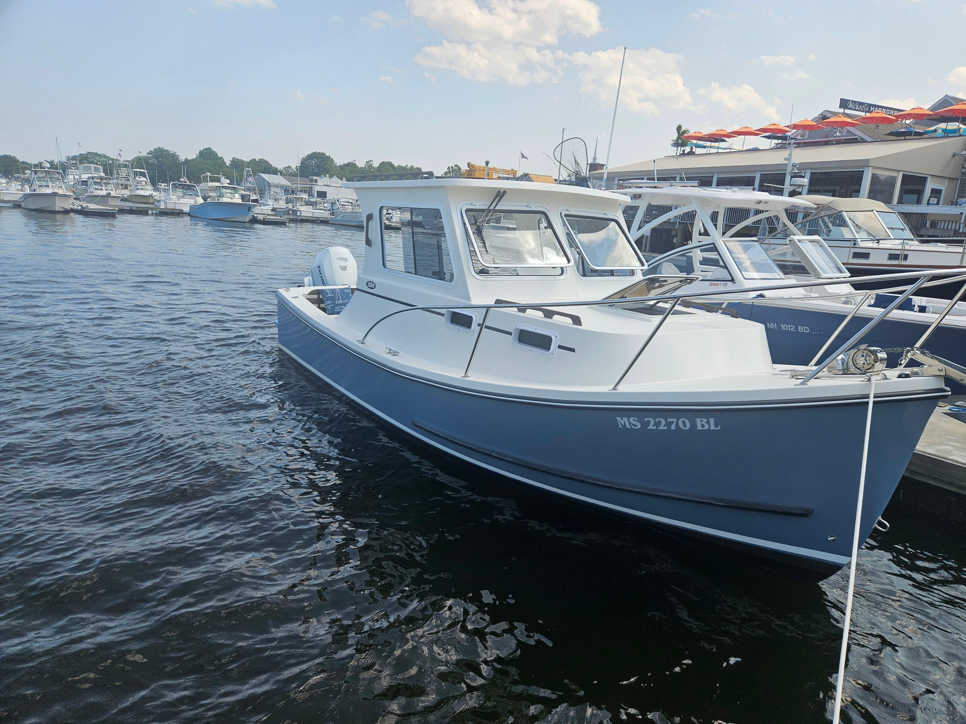 2019 Eastern 248 Explorer boat docked at marina, calm water, clear sky.