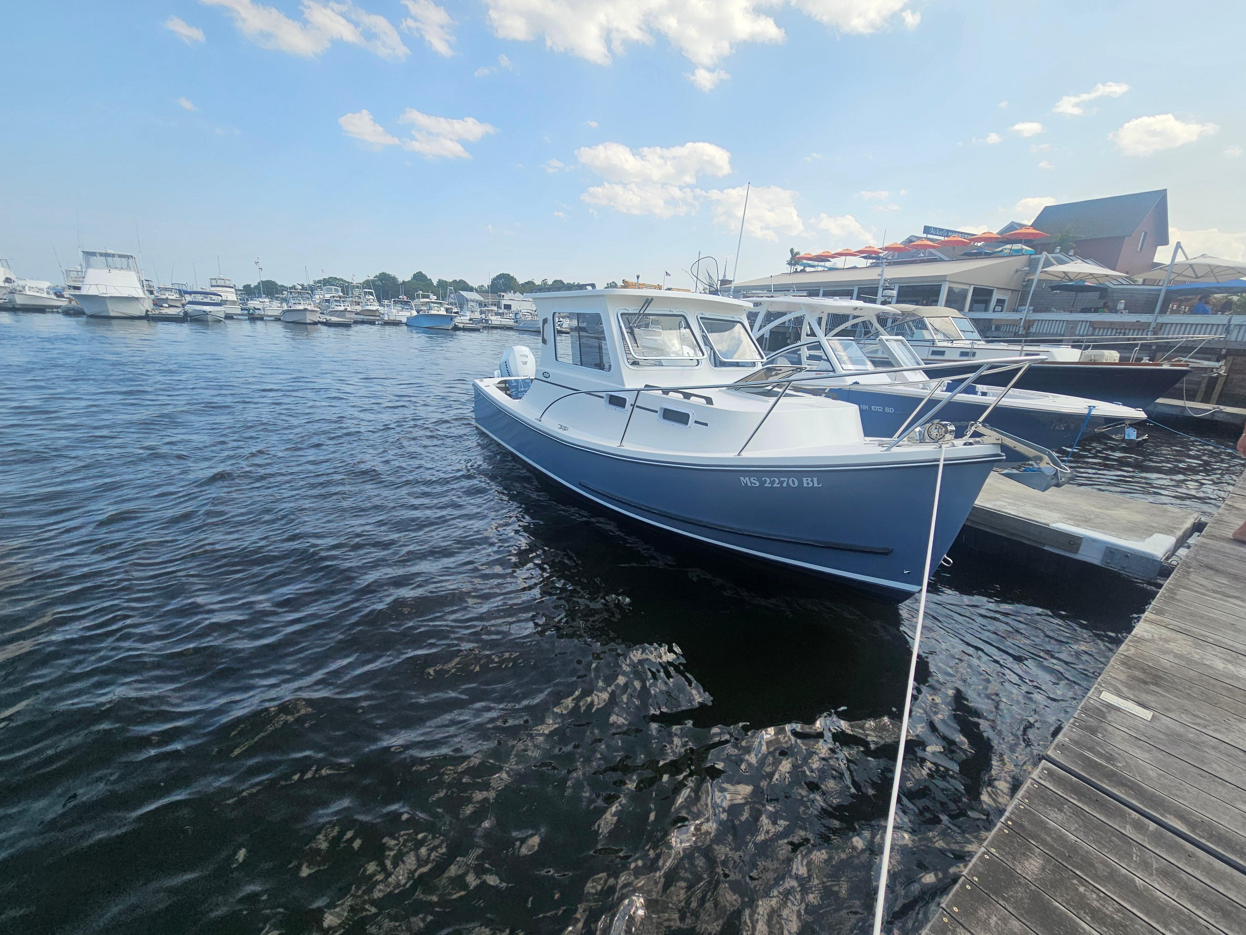2019 Eastern 248 Explorer boat docked at a marina under a clear sky.