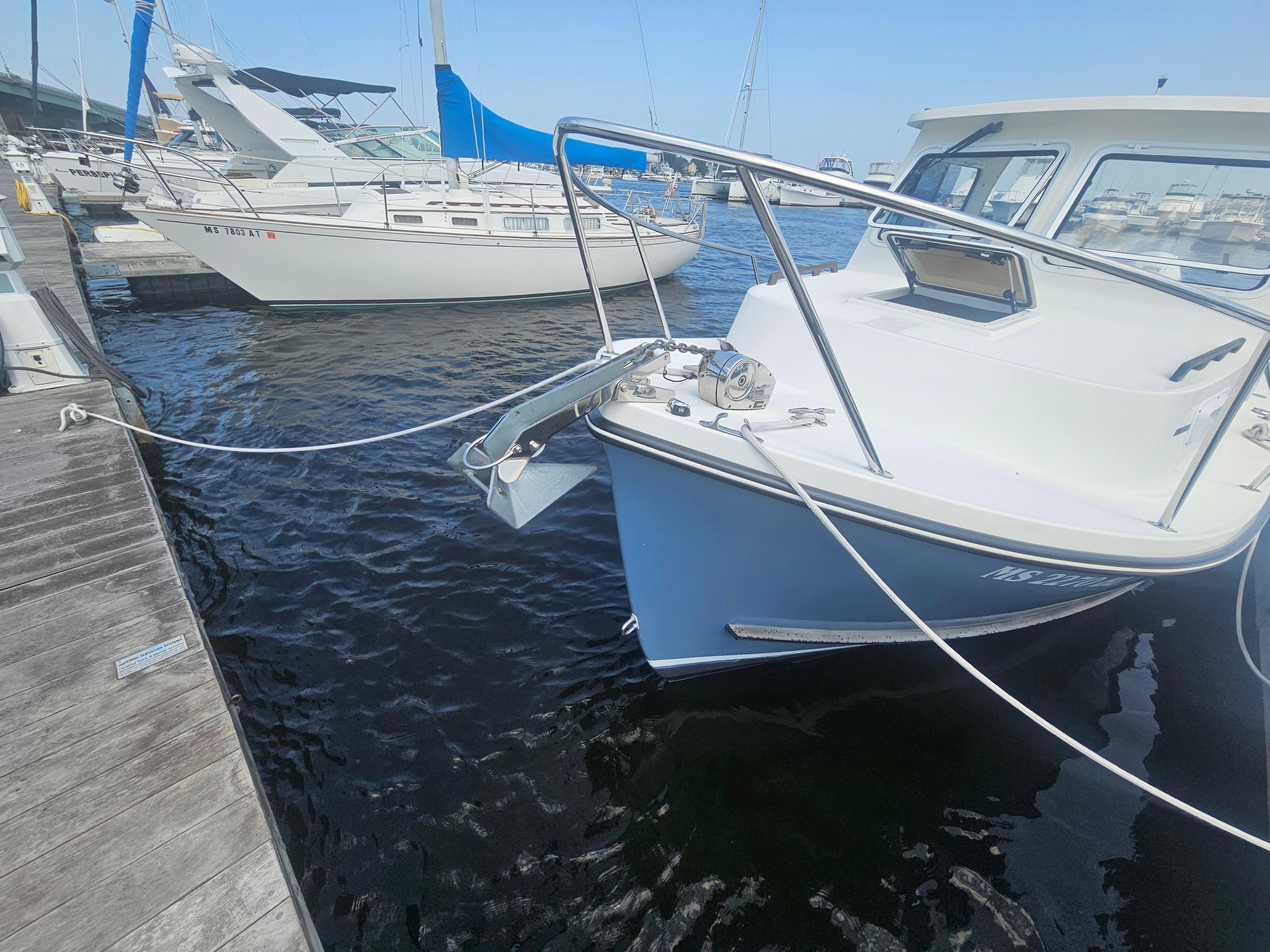 2019 Eastern 248 Explorer boat docked at marina, adjacent to sailboats.