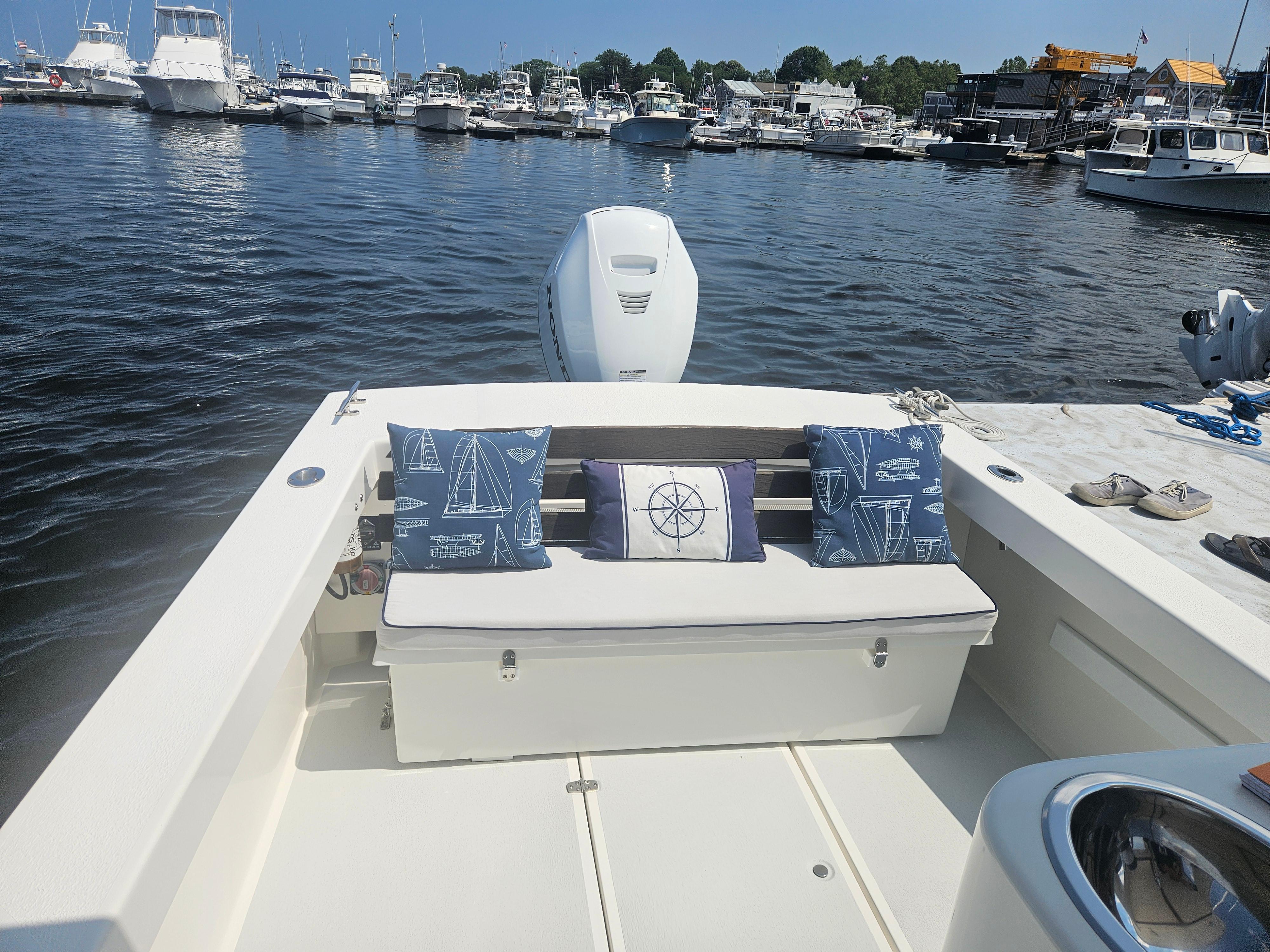 2019 Eastern 248 Explorer boat interior with nautical-themed cushions, docked at a marina.