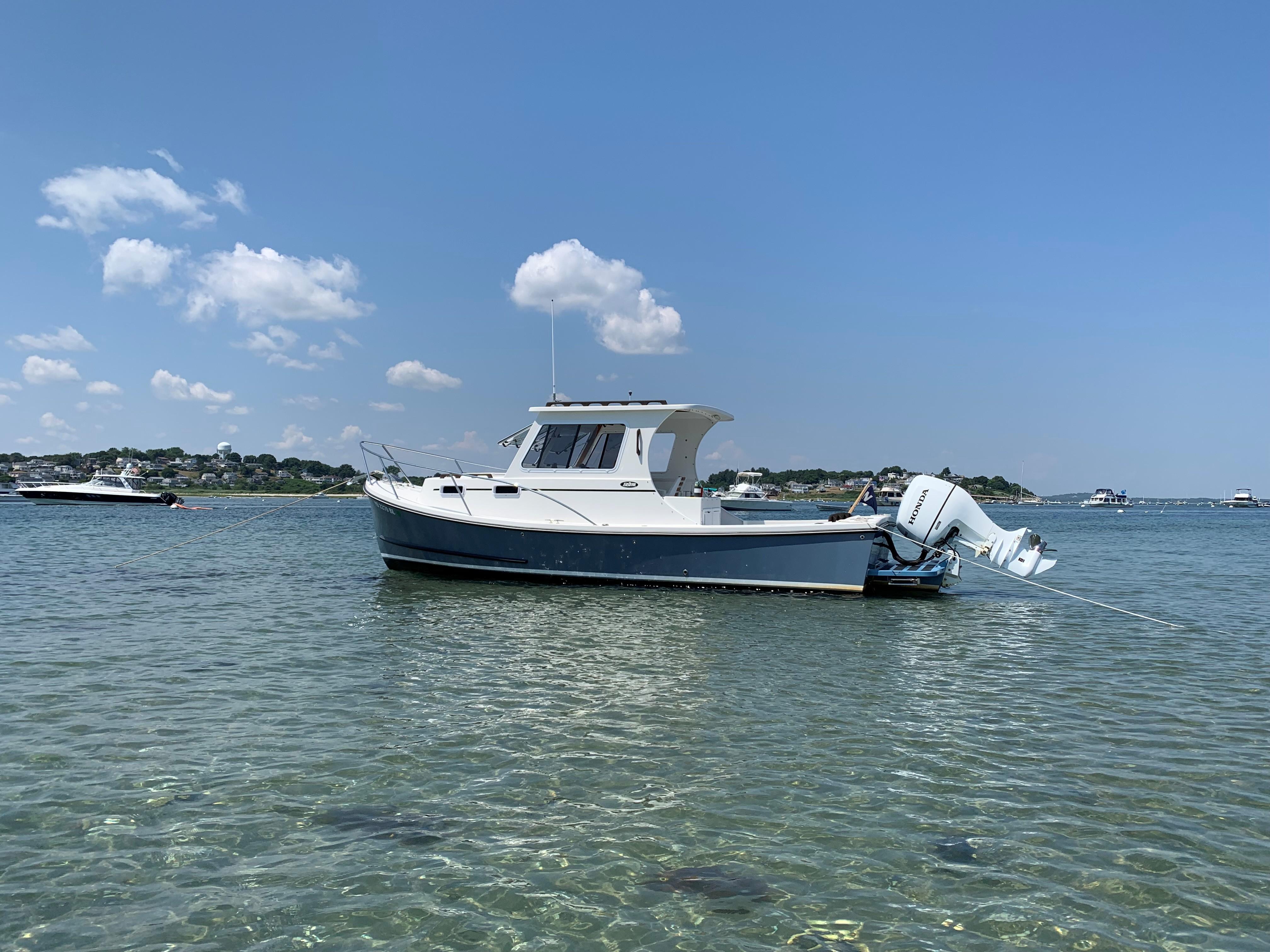 2019 Eastern 248 Explorer boat anchored in clear water under a blue sky.