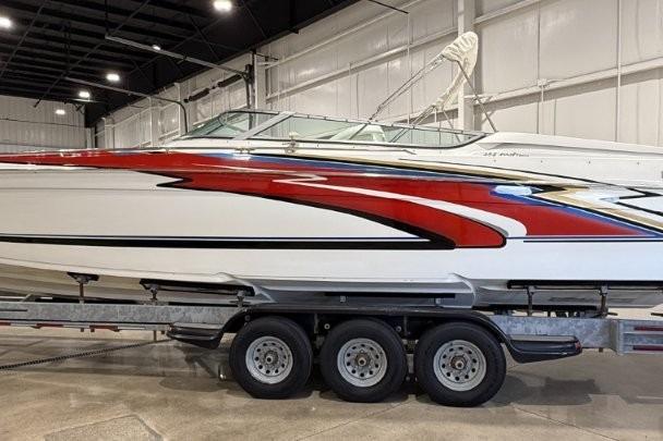 1998 Formula 382 FASTech boat with vibrant red and white design on a trailer in a warehouse.