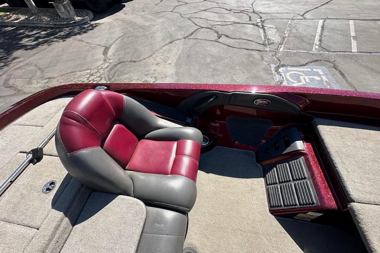 2010 Ranger 178 VS boat interior with red and gray seating, parked on cracked pavement.