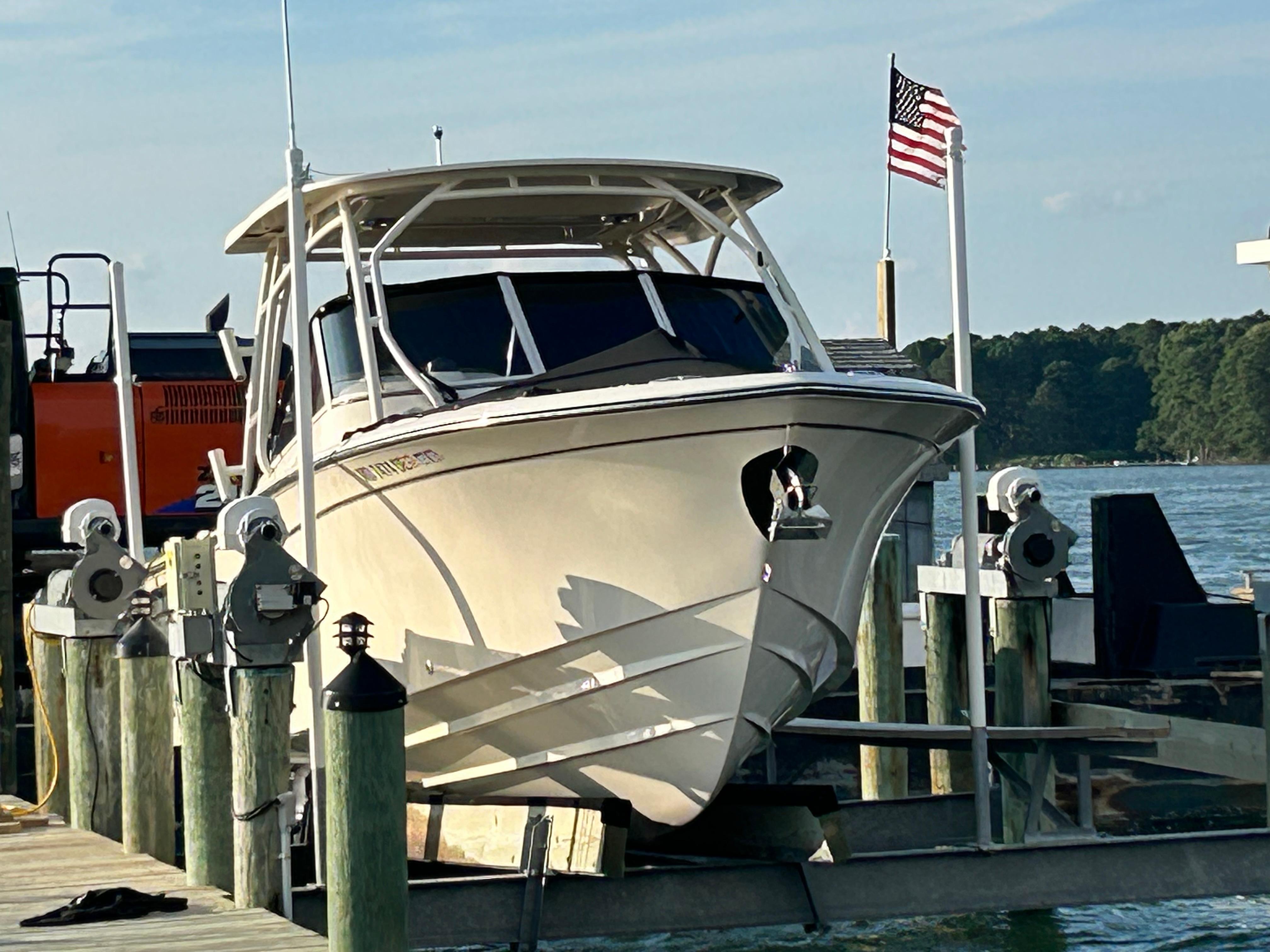 2023 Grady-White Freedom 275 boat docked with American flag in background.