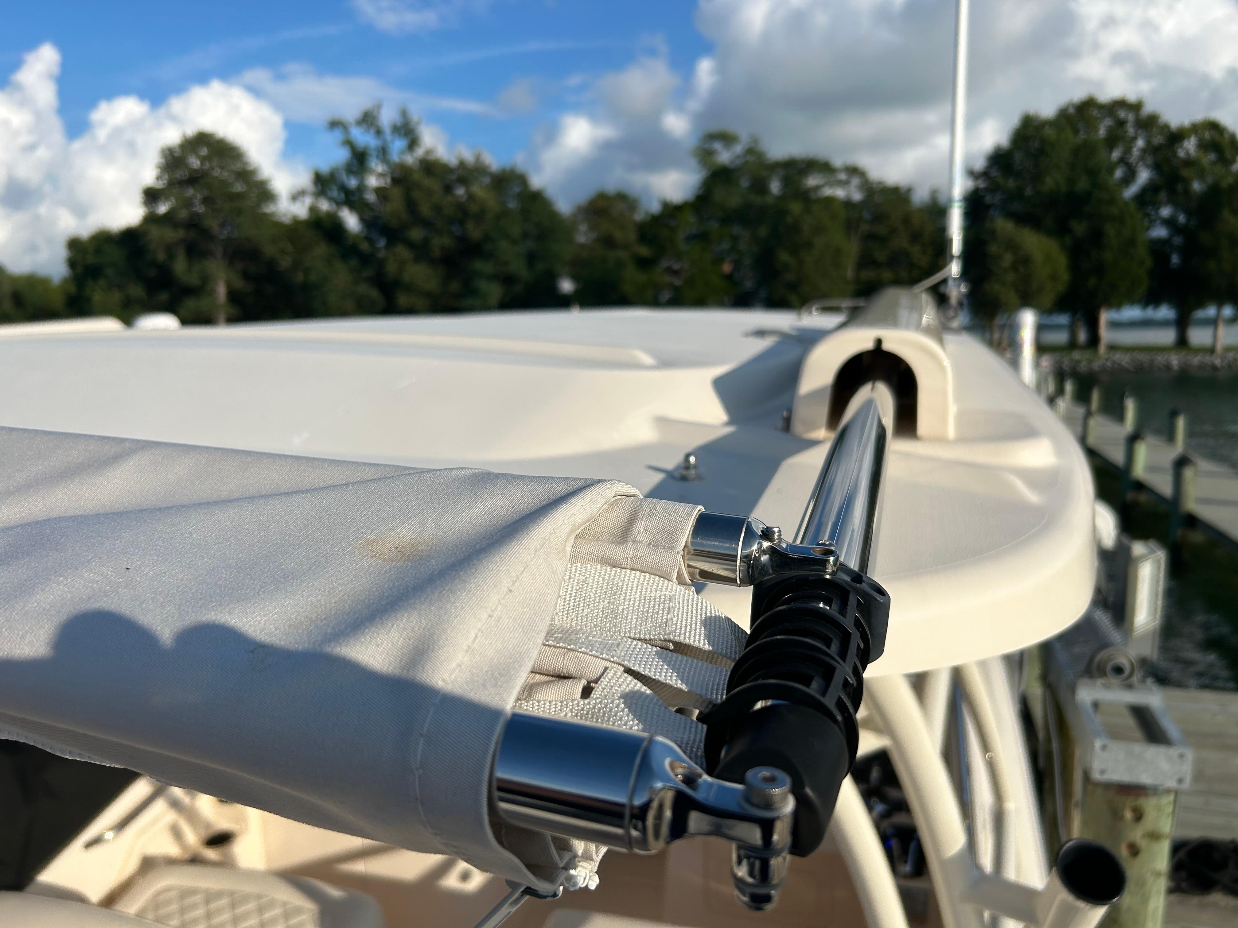 2023 Grady-White Freedom 275 boat detail with canopy and railing, docked by trees.