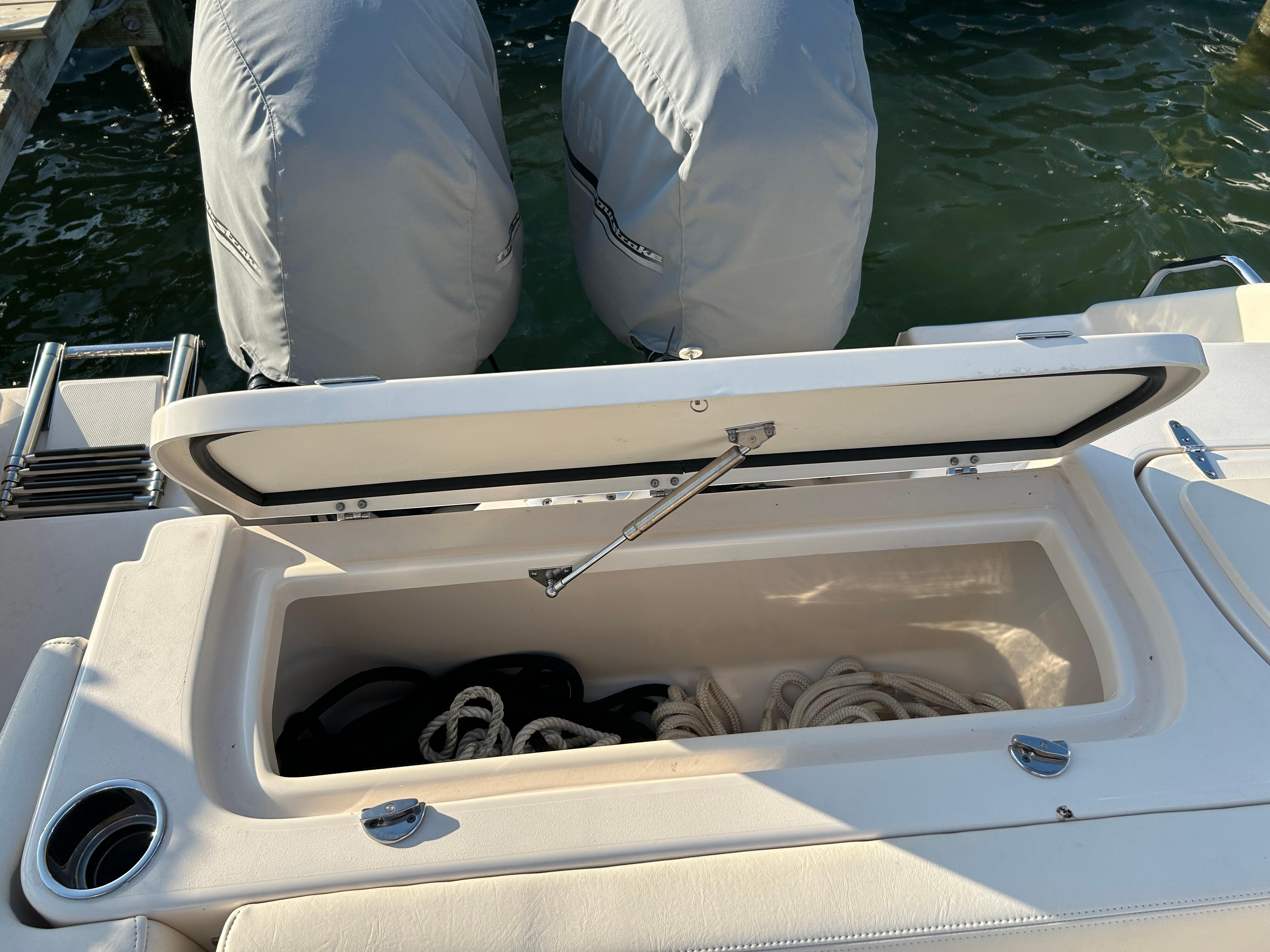 2023 Grady-White Freedom 275 boat storage compartment with ropes, docked by water.
