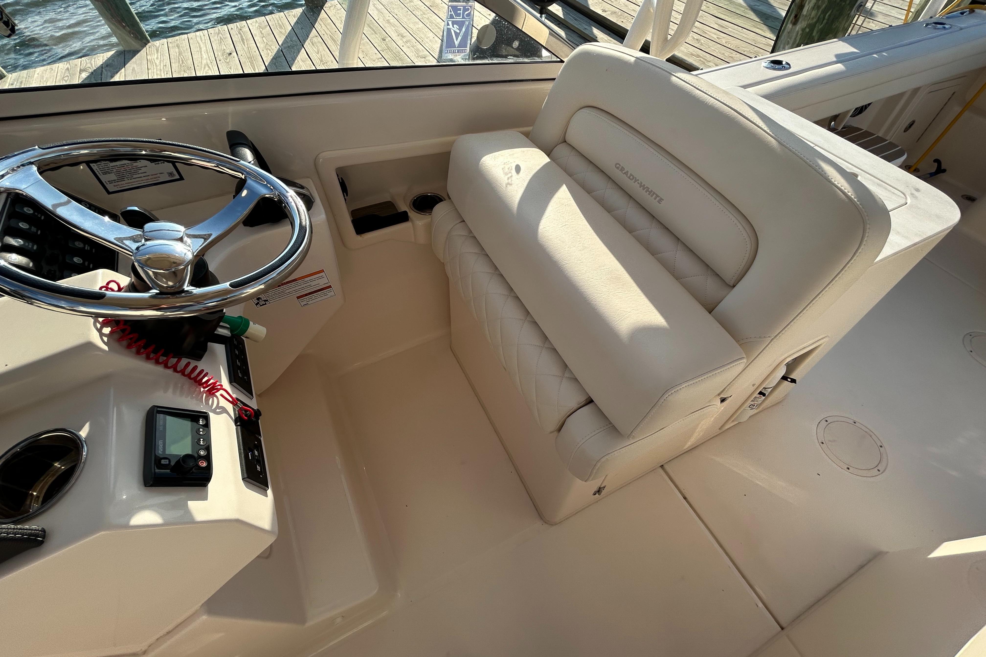 2023 Grady-White Freedom 275 boat interior with steering wheel and cushioned seating.
