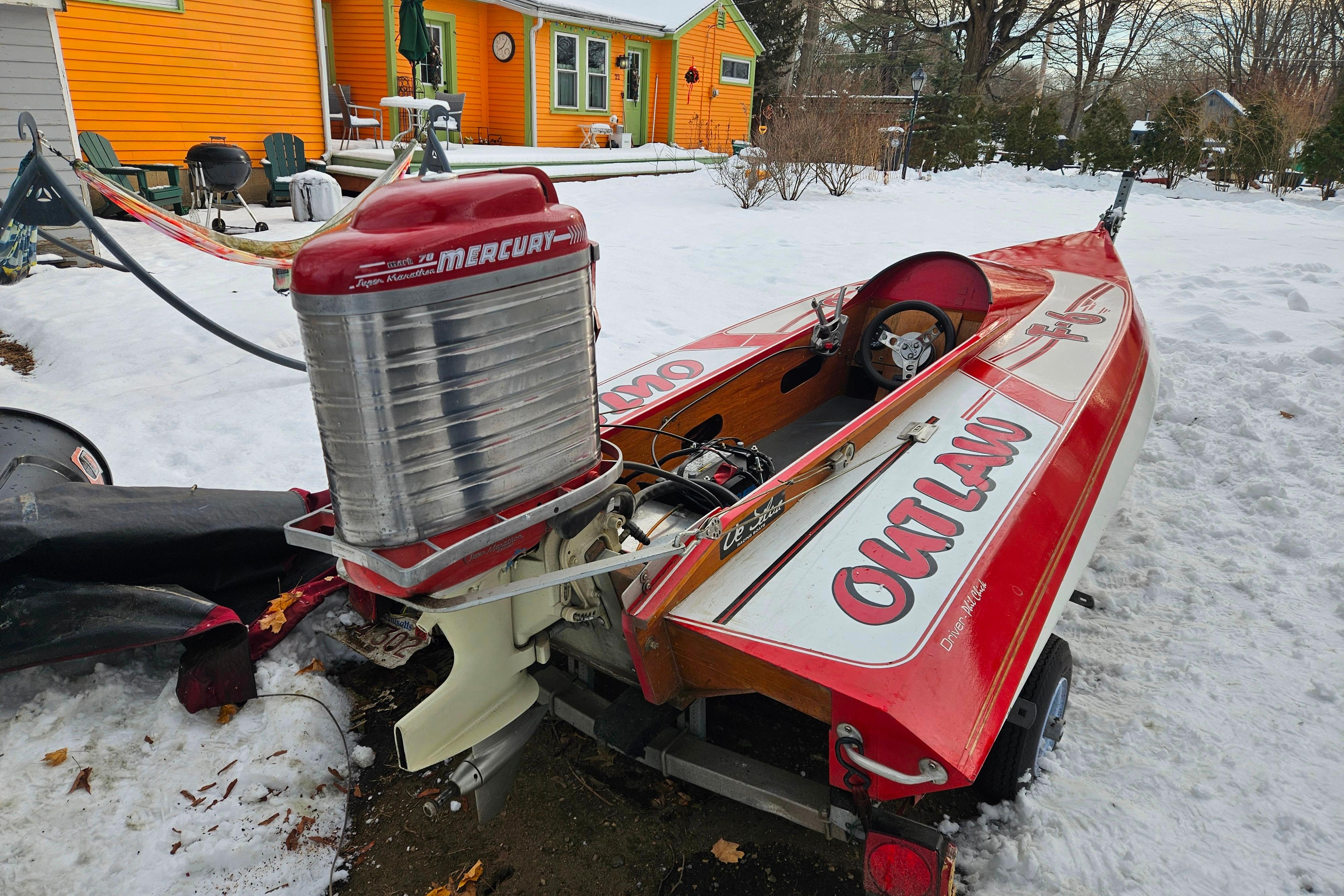 1987 De Silva F Class Race boat with Mercury engine in snowy yard.