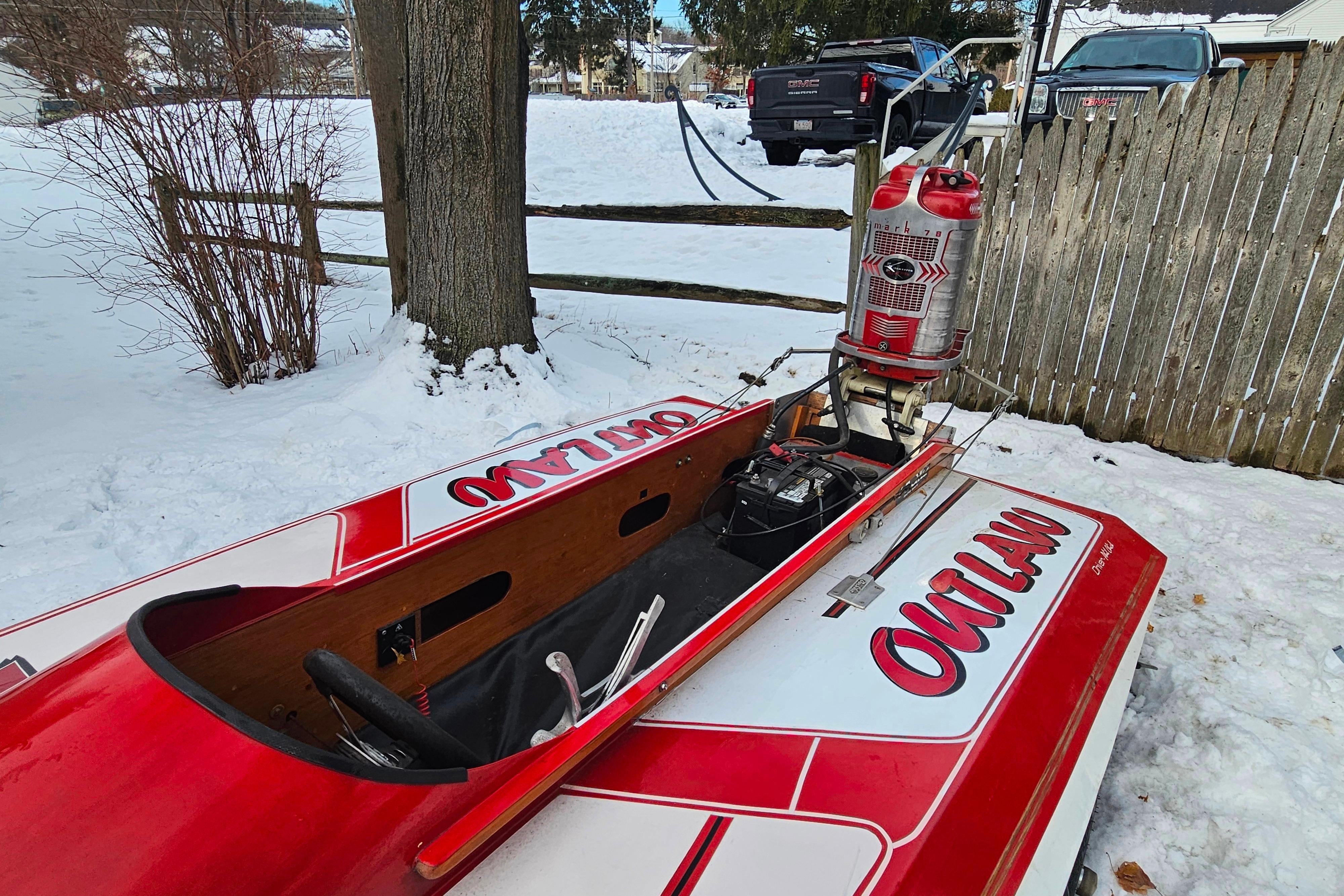 1987 De Silva F Class Race boat in snow, featuring u0022Outlawu0022 design and vintage outboard motor.