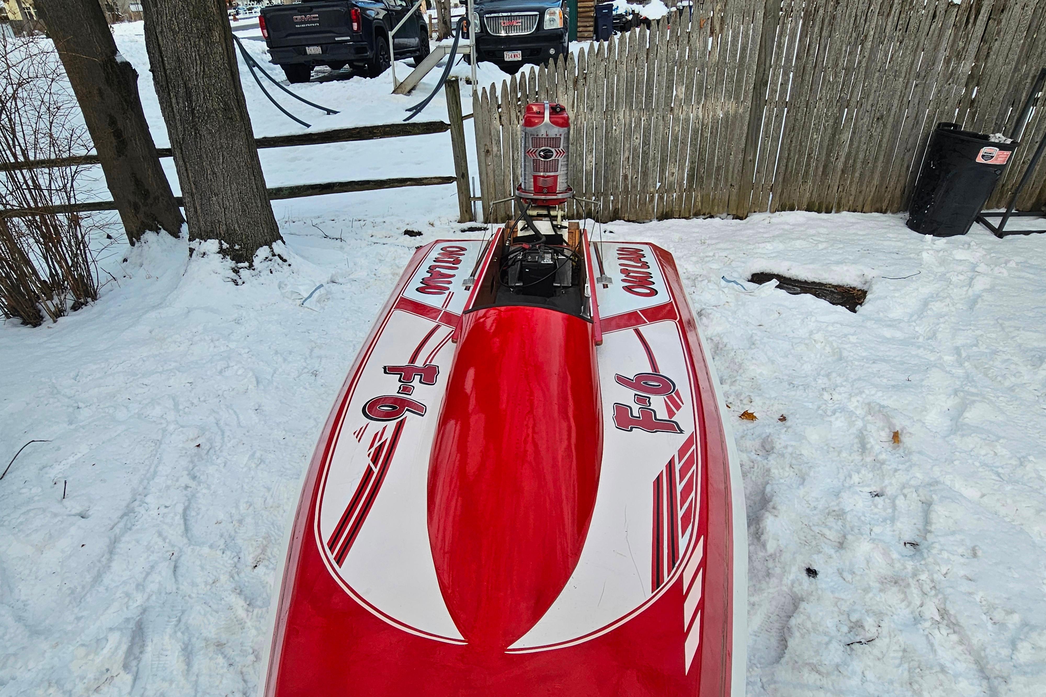 1987 De Silva F Class Race boat in snowy yard, red and white design.