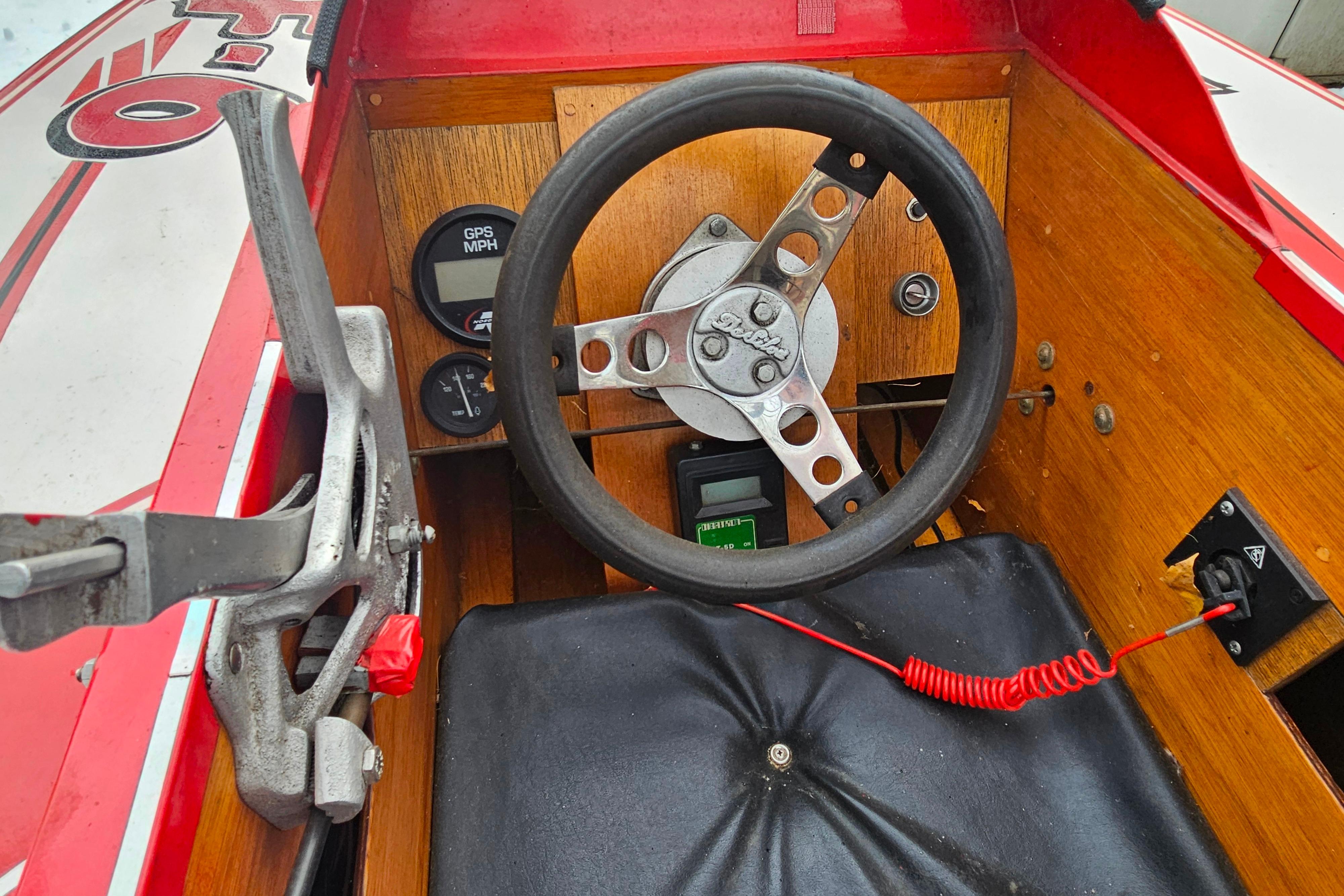 Interior of a 1987 De Silva F Class Race boat with wooden dashboard and steering wheel.