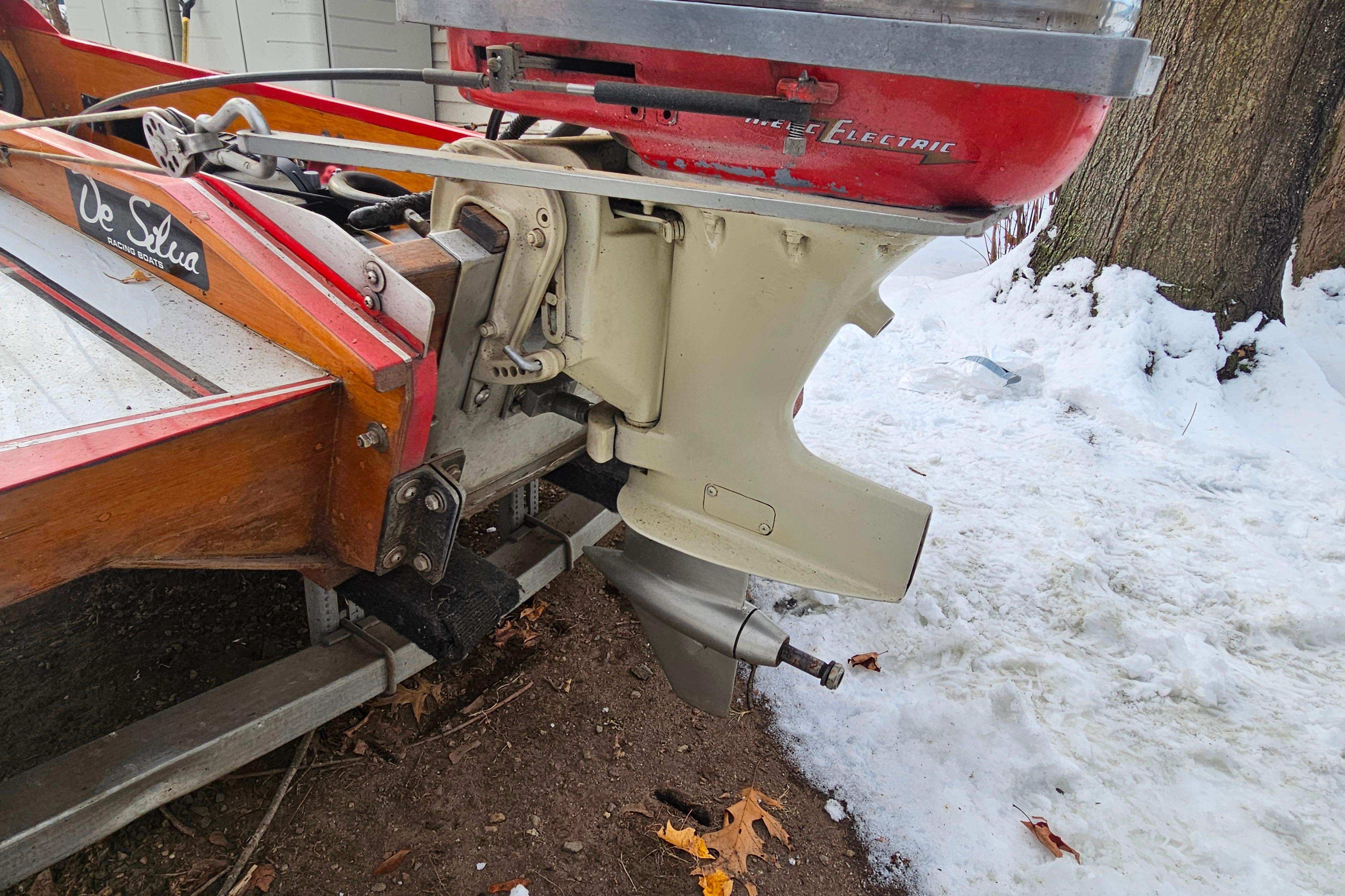 1987 De Silva F Class Race boat with vintage outboard motor in snowy setting.