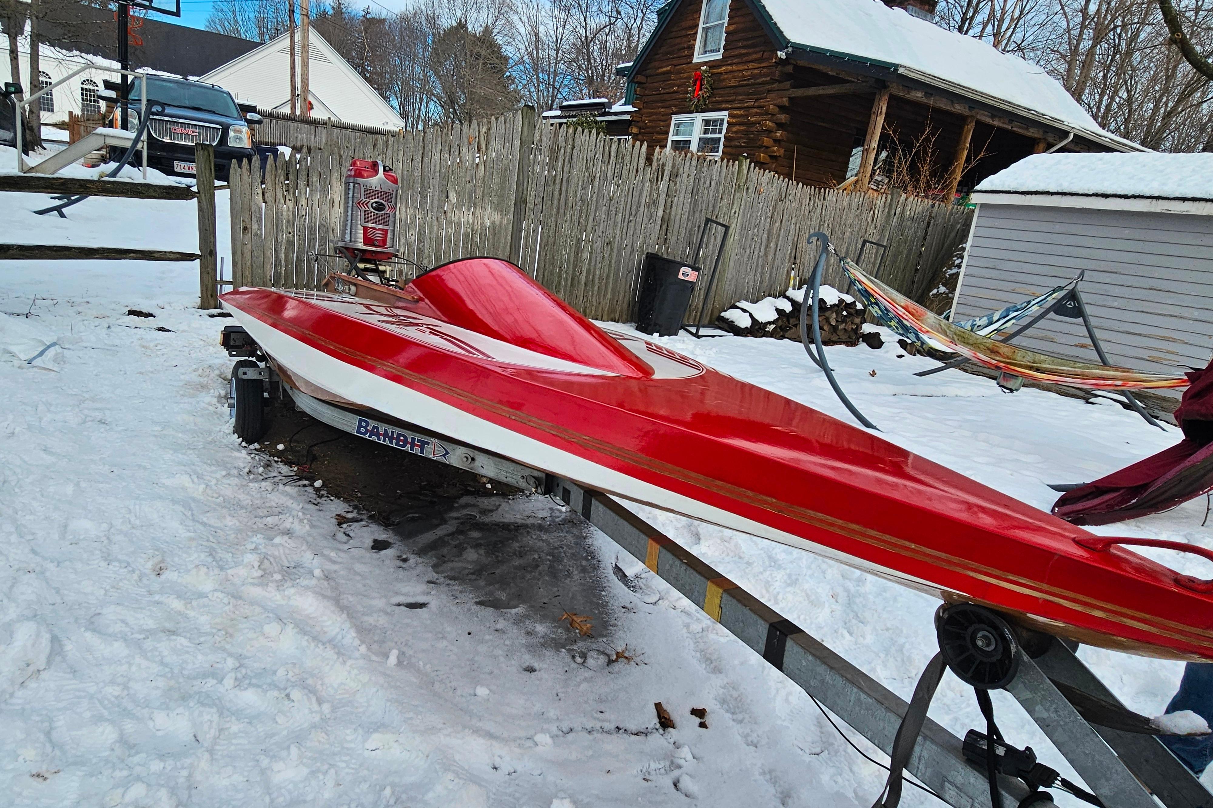 Red 1987 De Silva F Class Race boat on trailer in snowy yard.