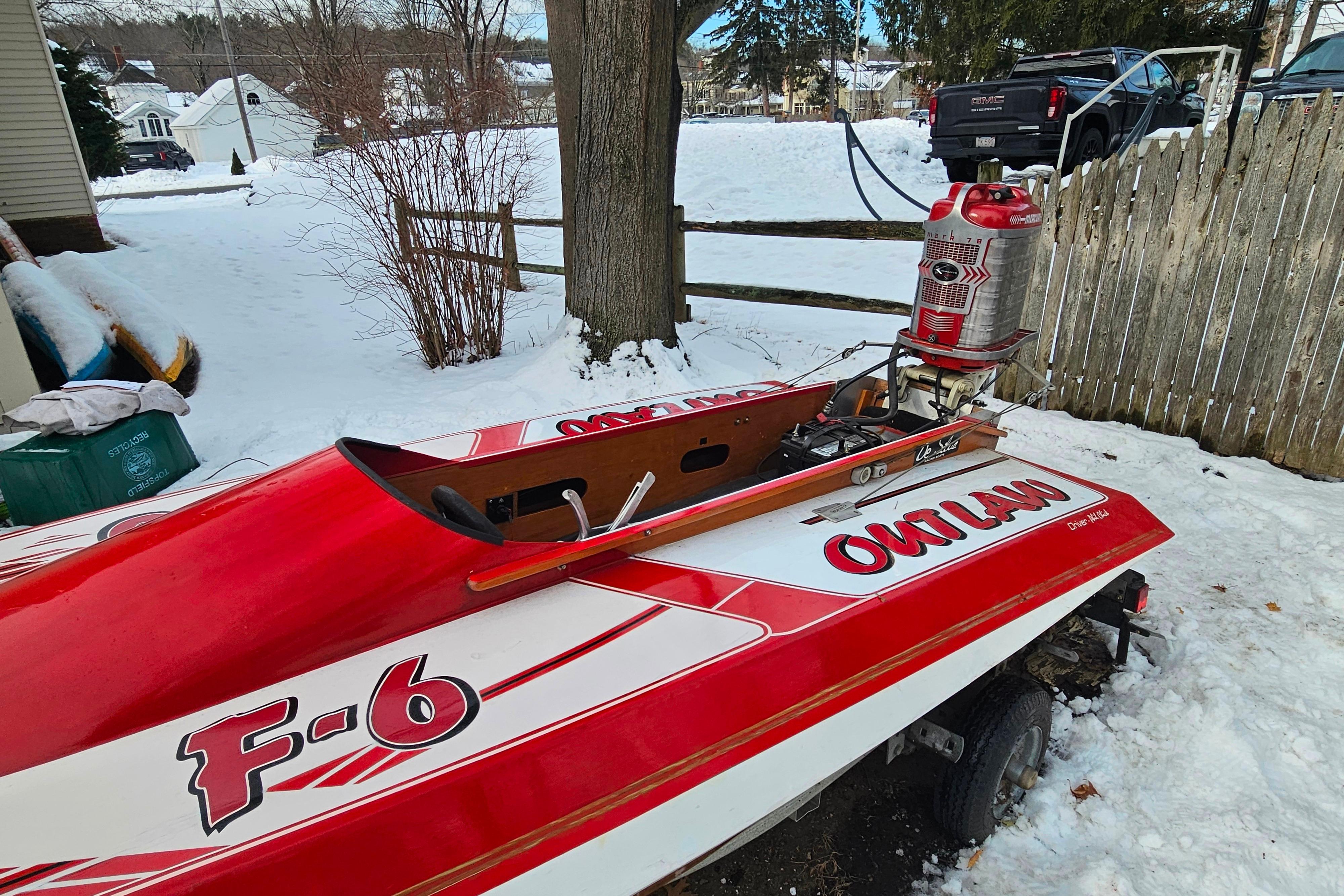 Red 1987 De Silva F Class Race boat in snowy yard, labeled u0022Outlaw.u0022