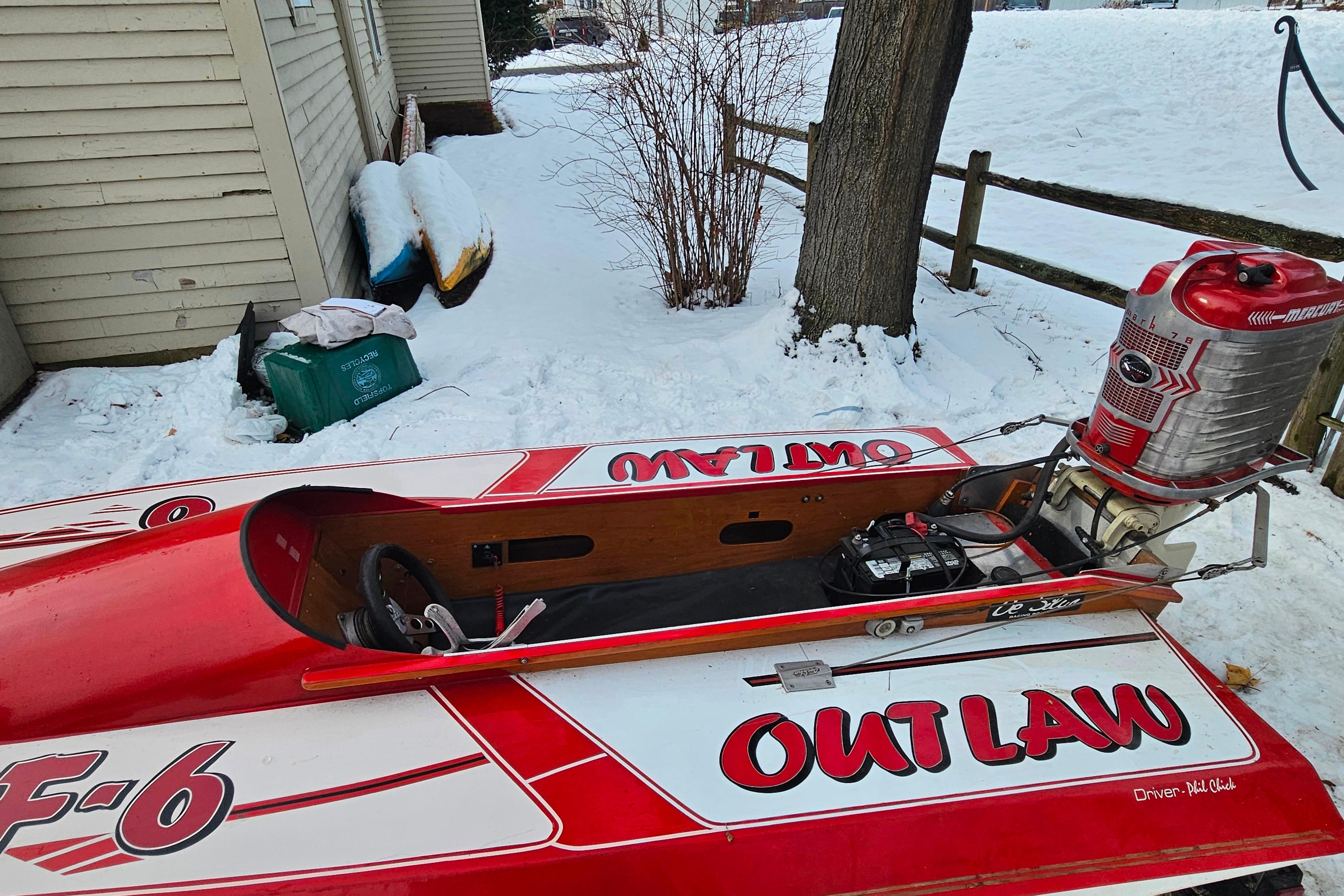 1987 De Silva F Class Race boat, red and white, parked in snowy yard.