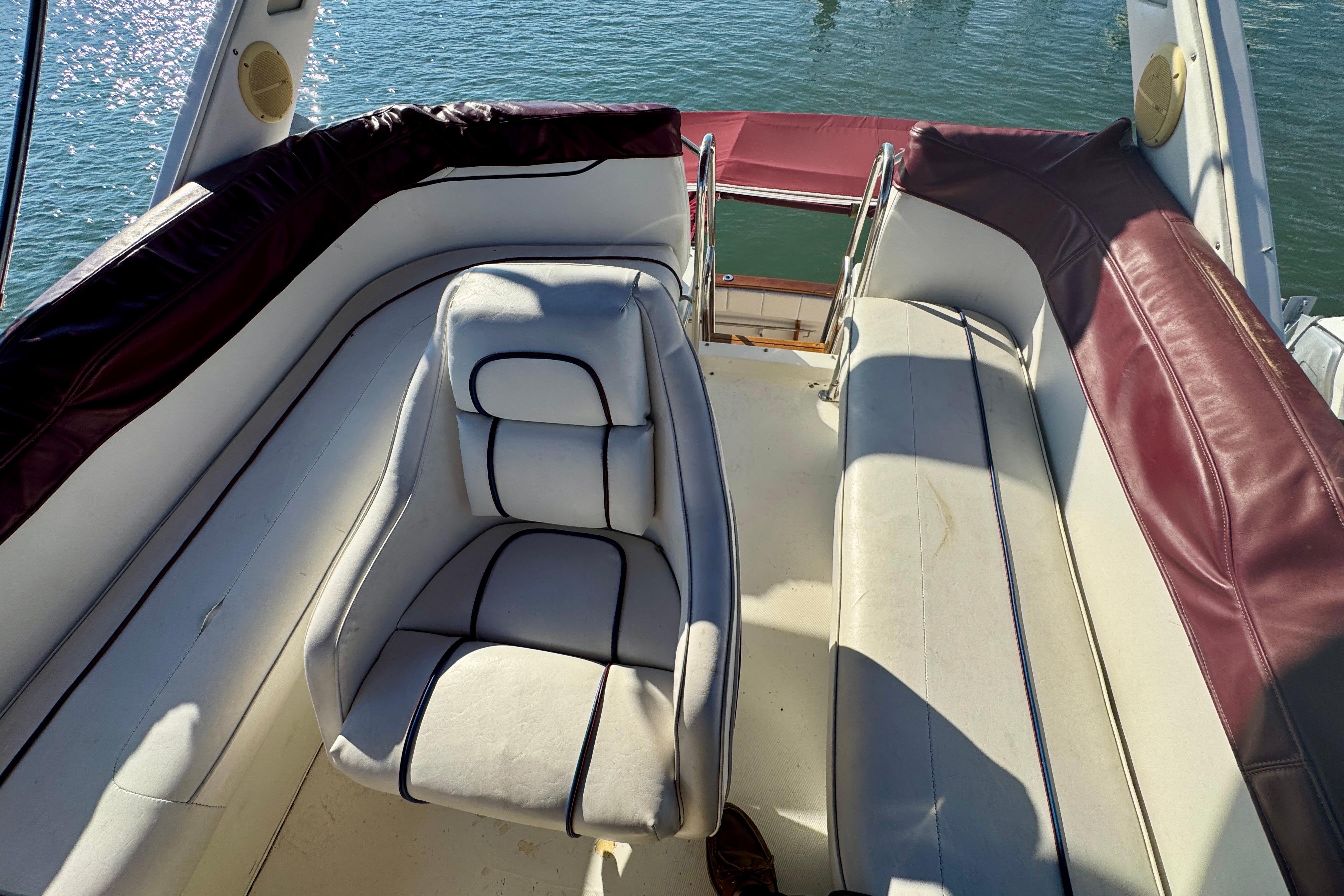 1989 Bayliner 3288 Motoryacht interior with white and maroon seating, overlooking water.