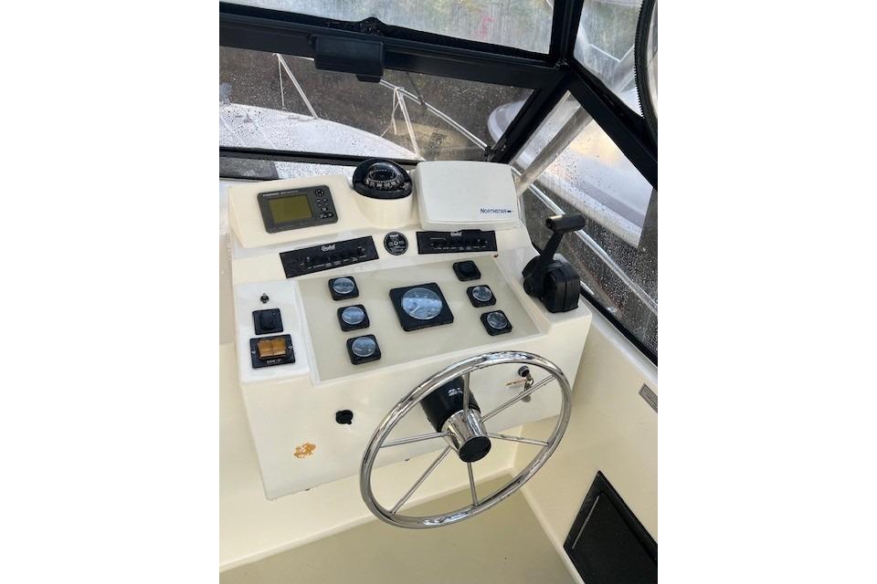 2001 Carolina Classic 25 Classic boat dashboard with steering wheel and navigation controls.