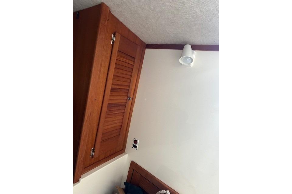Interior of 2001 Carolina Classic 25 Classic boat with wooden cabinet and wall light.