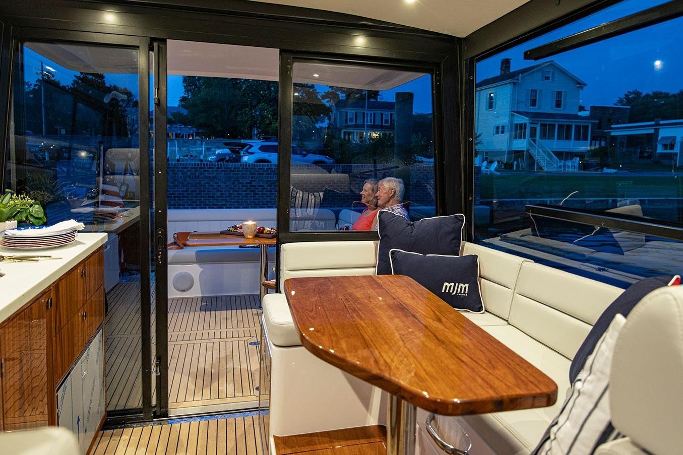 Luxurious interior of 2026 MJM 47 R yacht with elegant seating and wooden table.